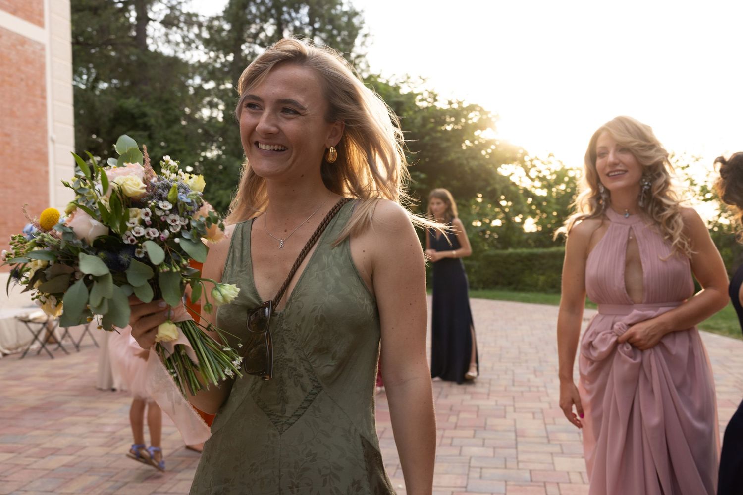 Wedding party members in colorful dresses celebrating outdoors.