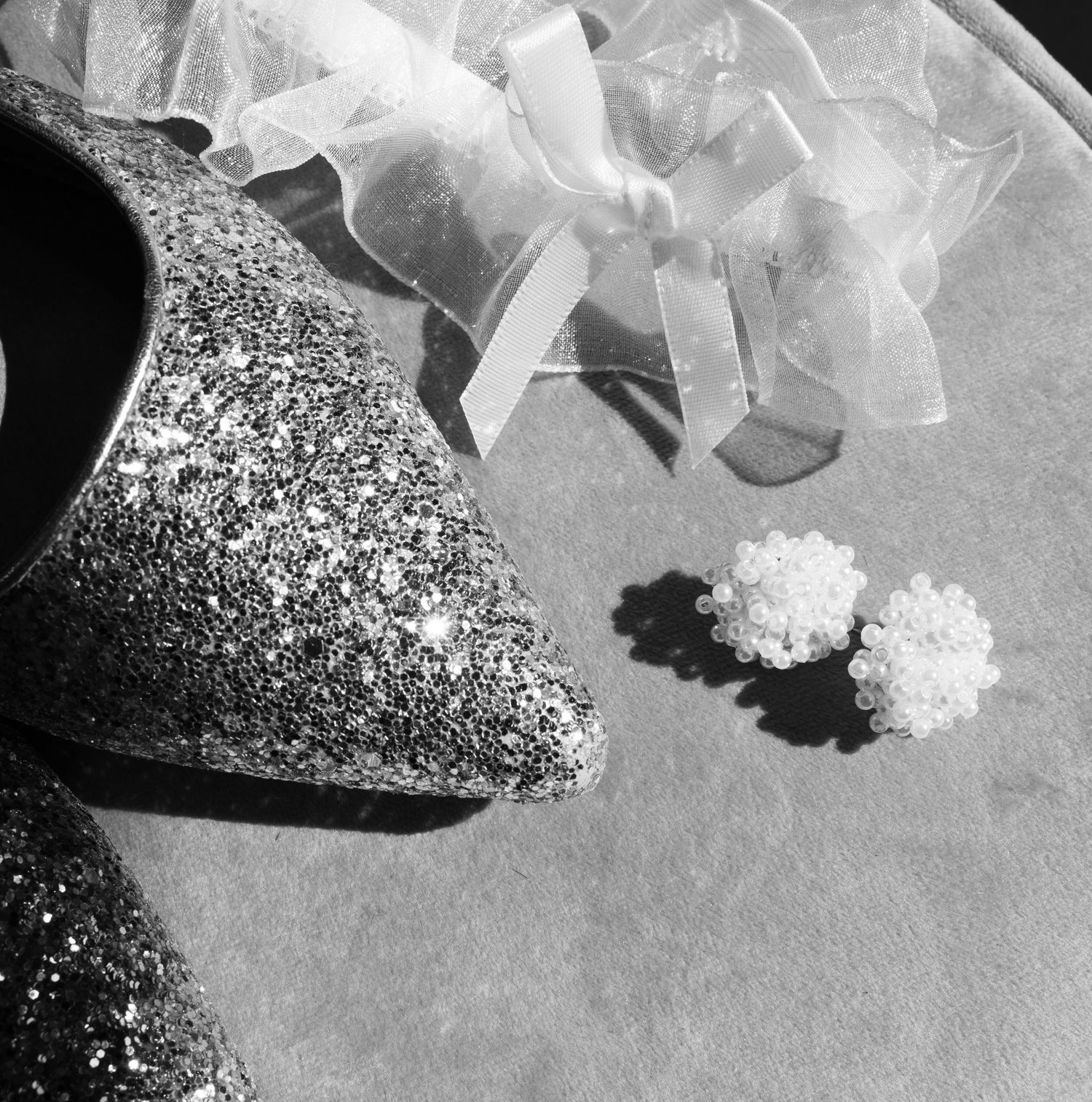 Artistic black and white detail shots of bridal shoes and floral accessories.
