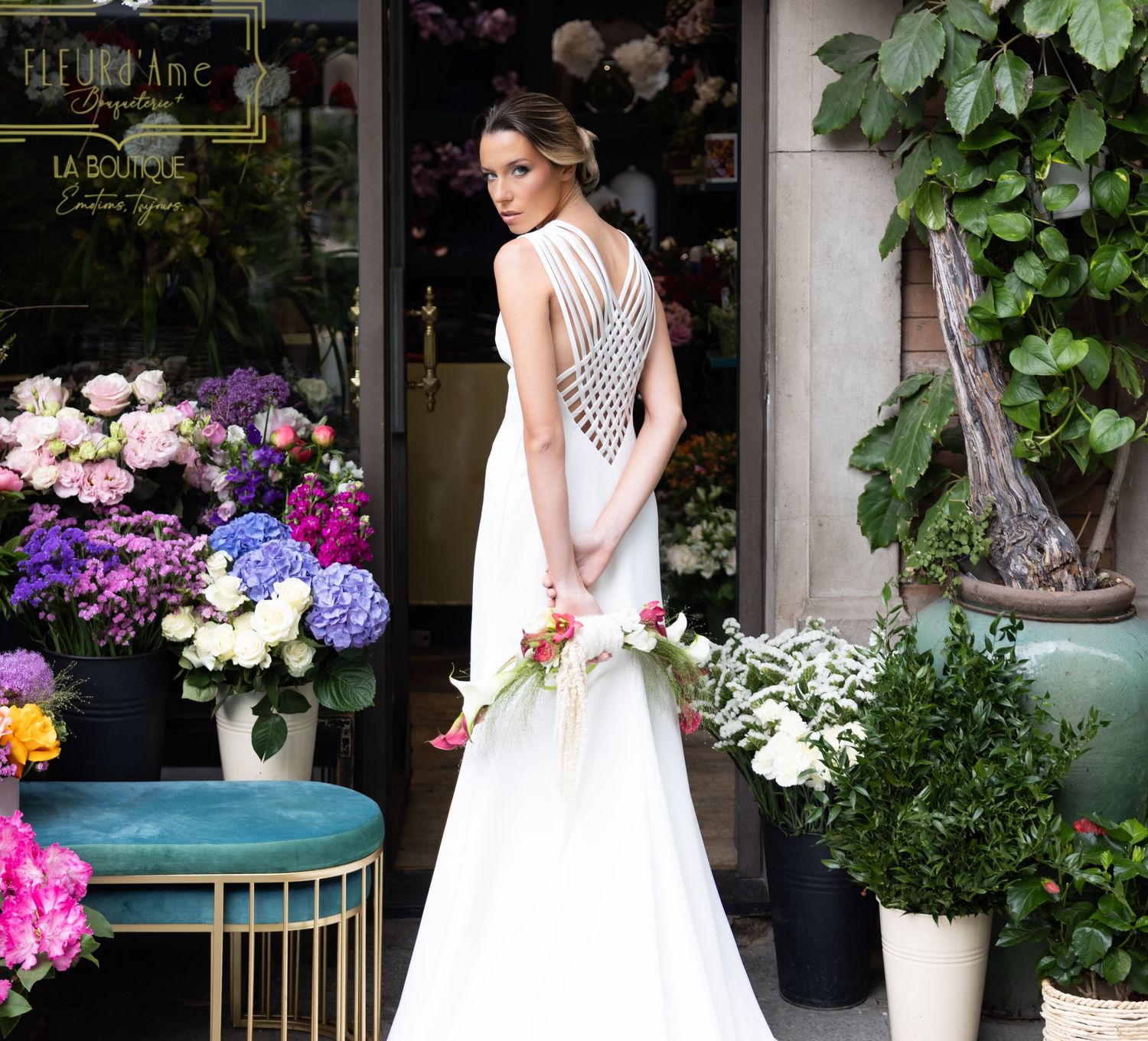 Elegant bridal portraits captured against a boutique entrance with lush floral arrangements.