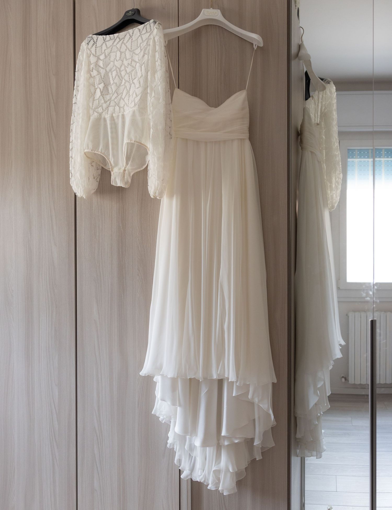White wedding dresses and gowns hanging on display in a bright dressing room.