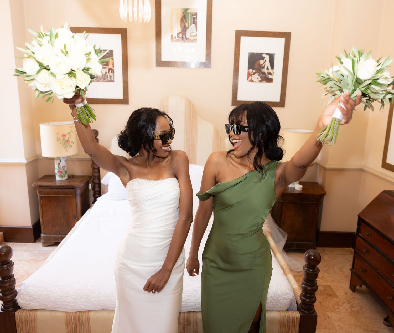 Bridesmaids in white dresses and olive green gowns pose together in an elegant indoor setting with floral bouquets.