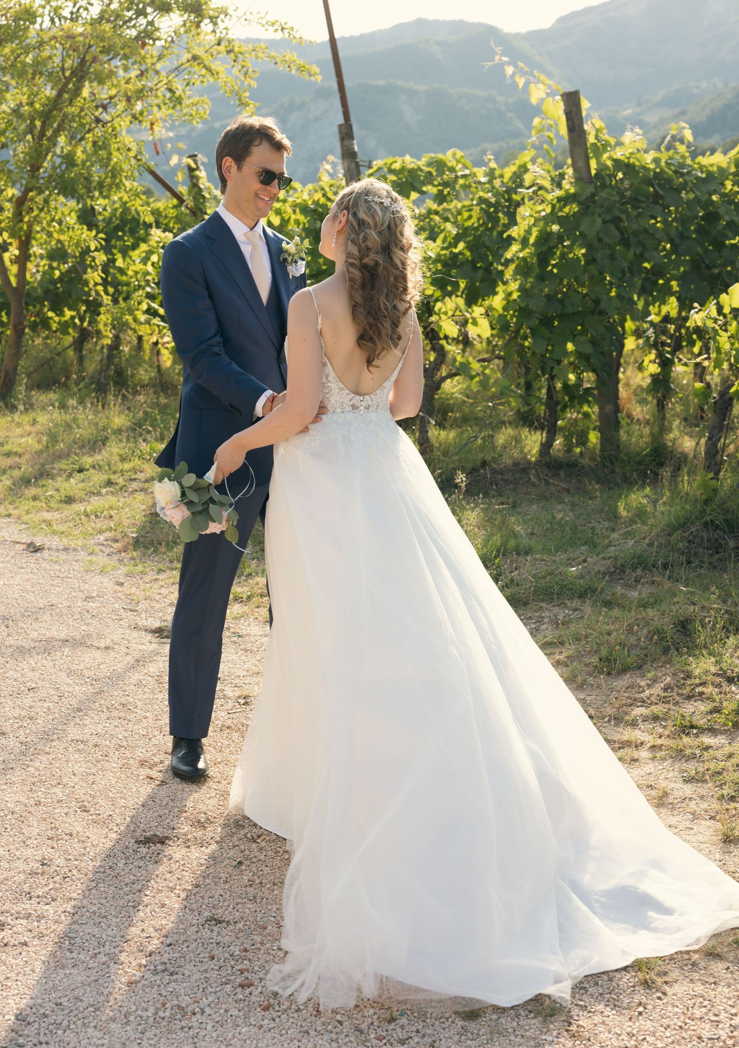 Romantic wedding portraits in a scenic vineyard with rolling hills in the background.
