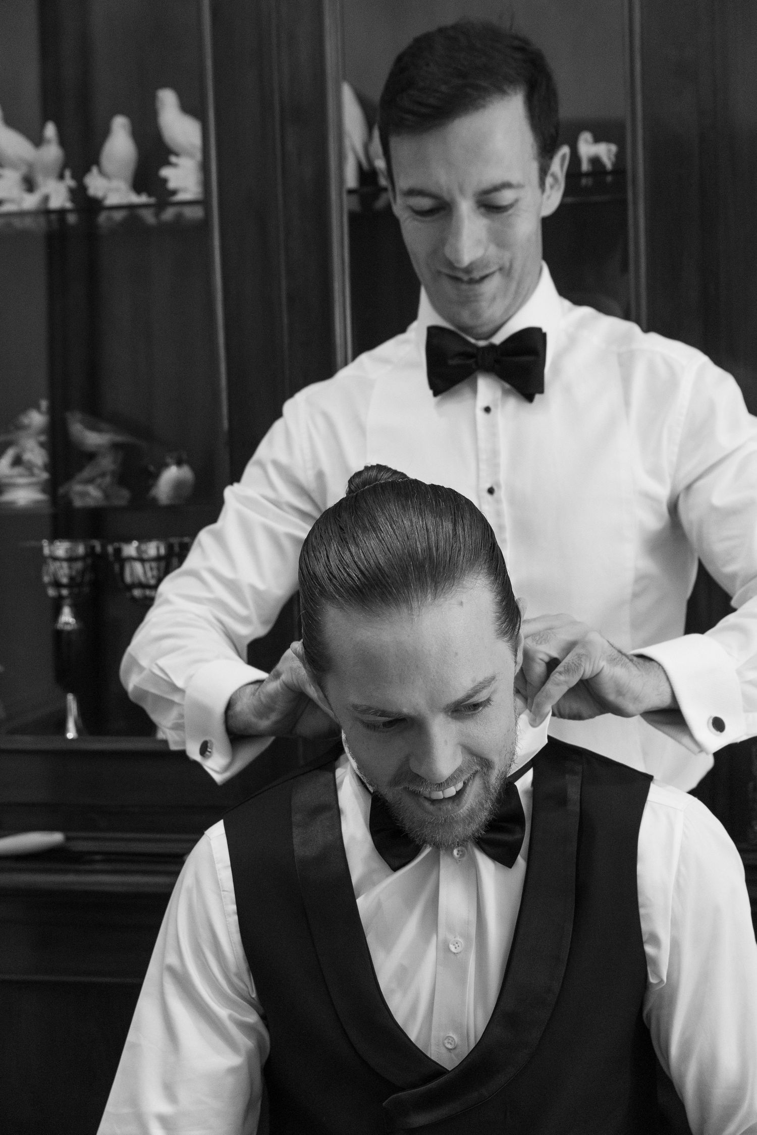 A black and white photo series showing people in formal attire getting ready with smiles and laughter.