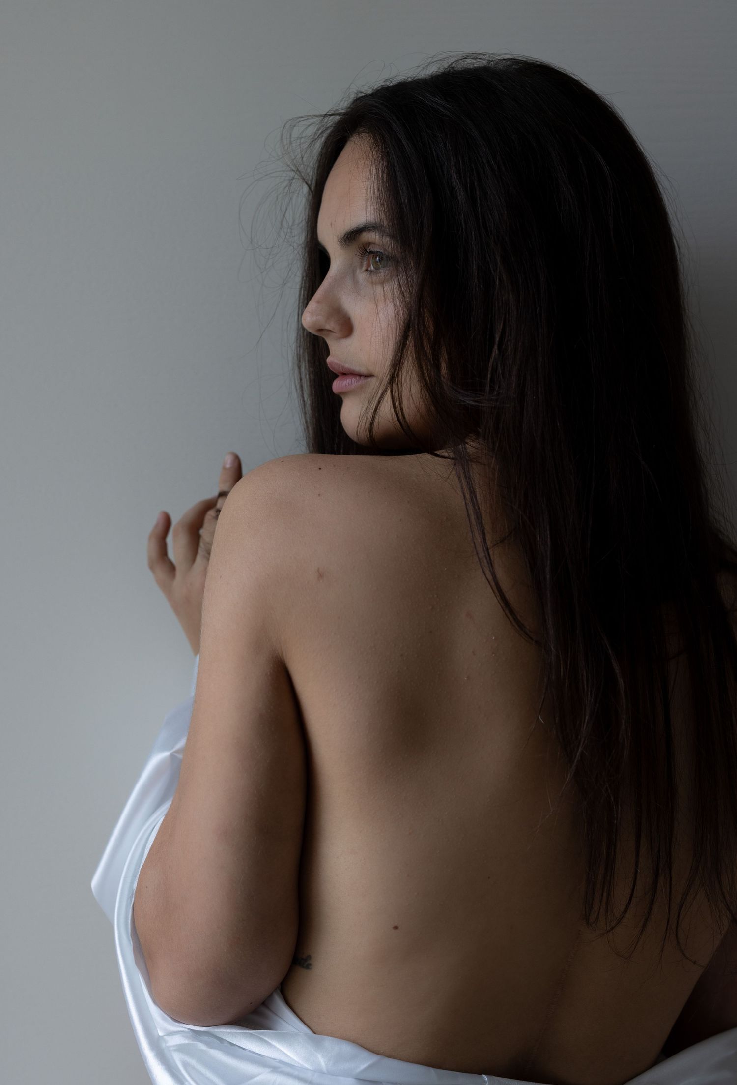 Artistic black and white portrait series showing shoulders and back in dramatic lighting.