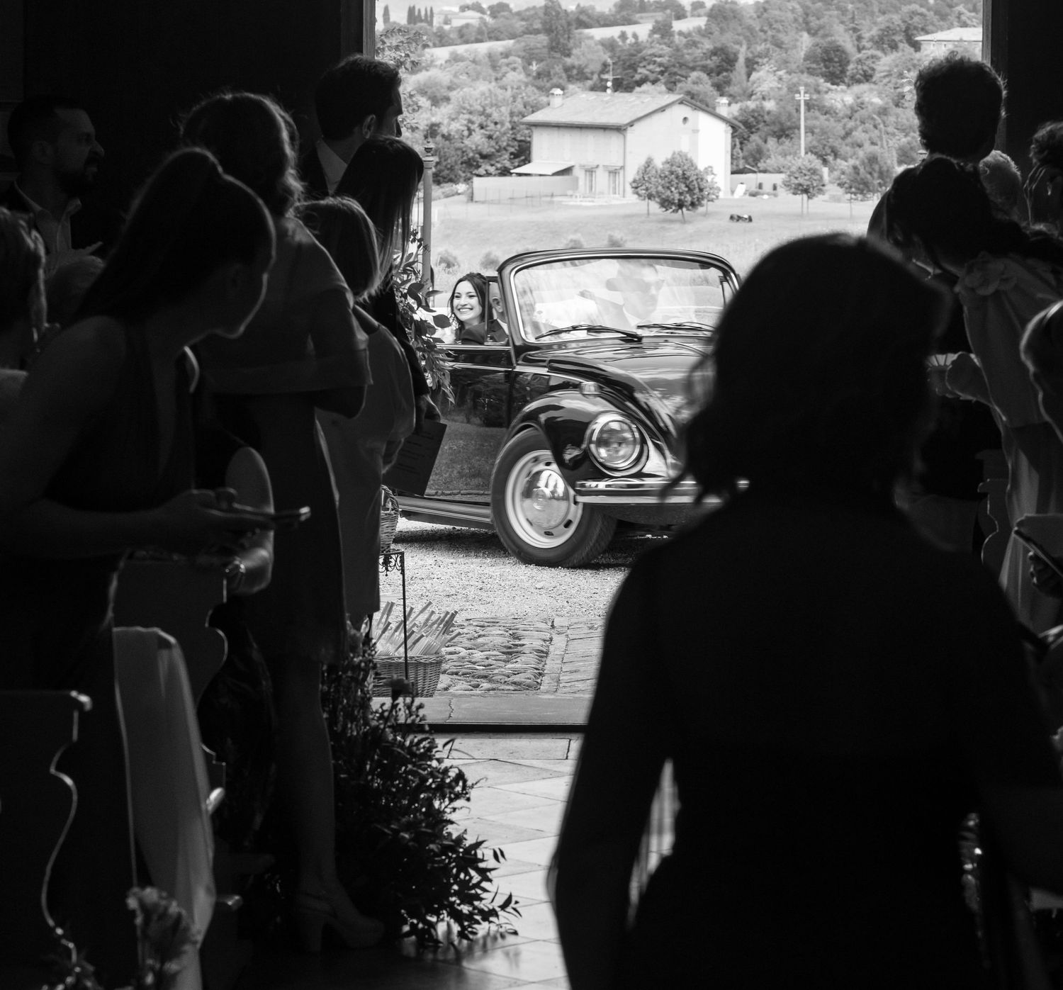 Silhouetted wedding guests gathered during an outdoor evening celebration.