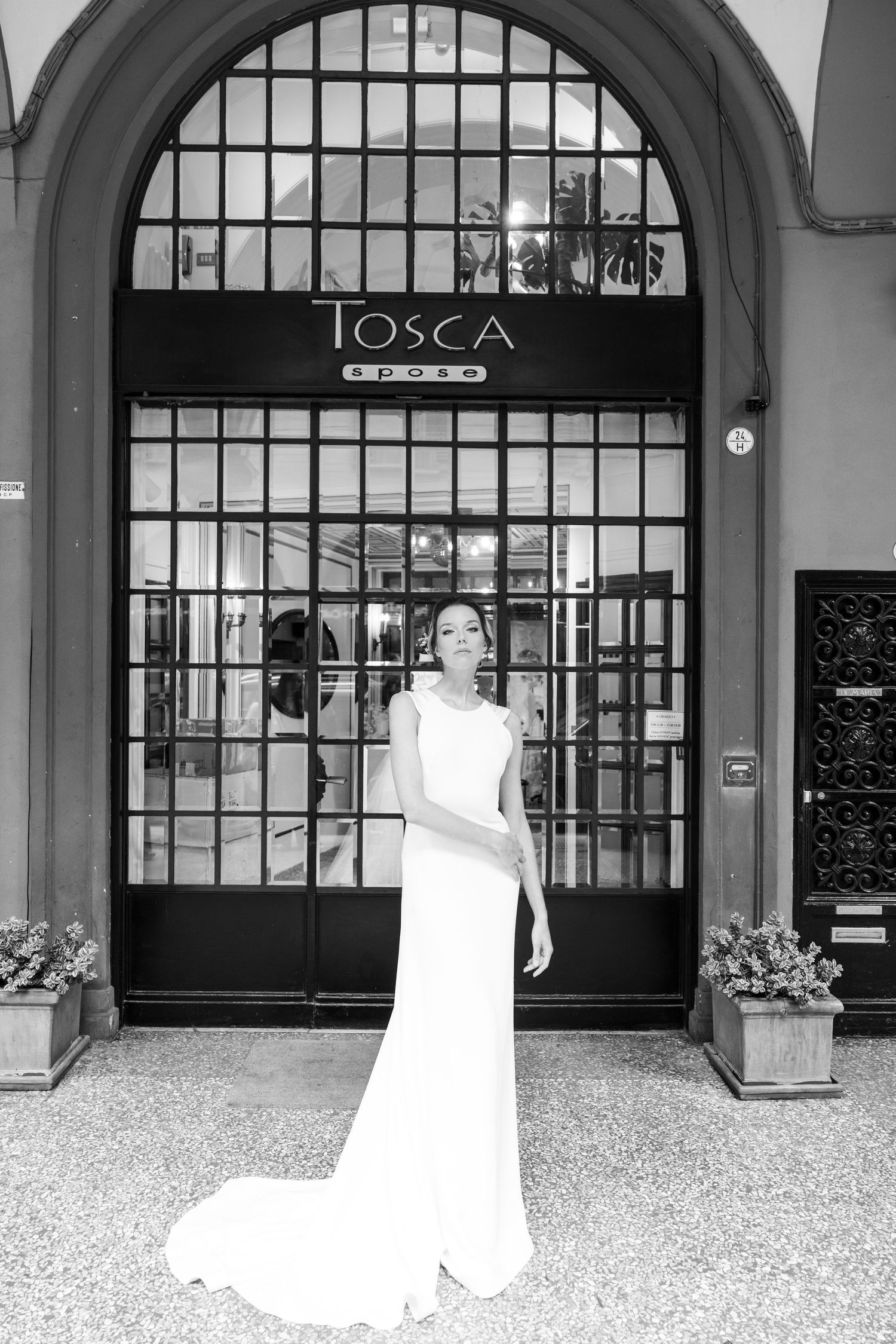 Black and white series showing a wedding dress against arched windows and iron gates.