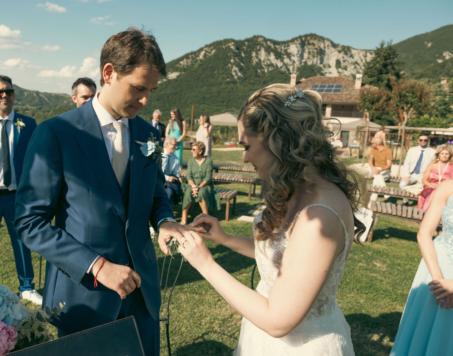 A couple exchanges rings during their wedding ceremony in a beautiful mountain landscape.