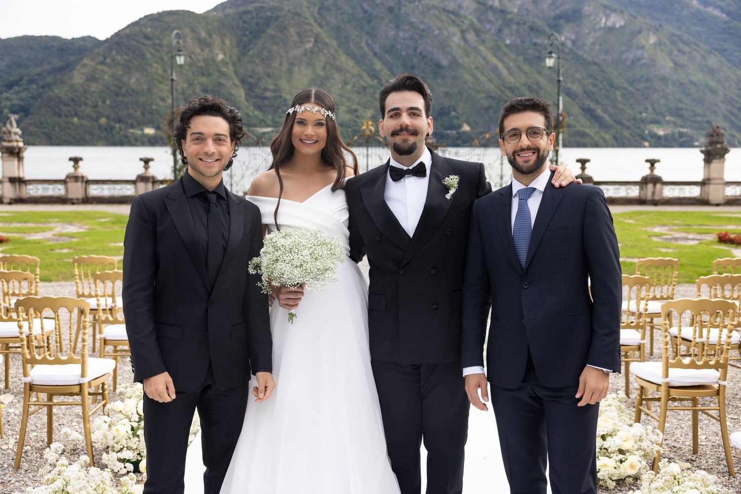 Wedding party members in formal attire gathered outside with mountain views.
