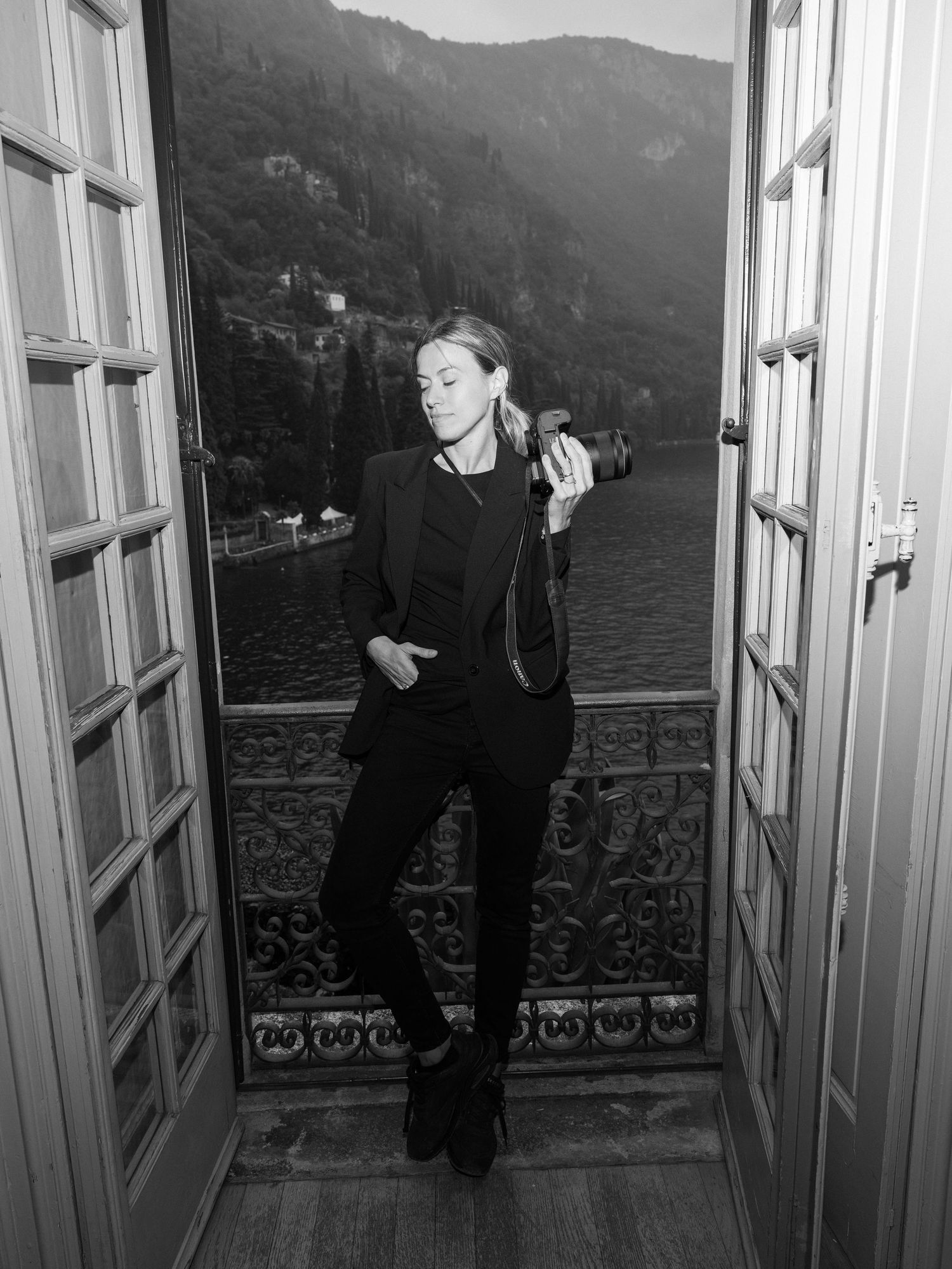 Black and white photos showing a balcony overlooking a scenic lake and mountain landscape.