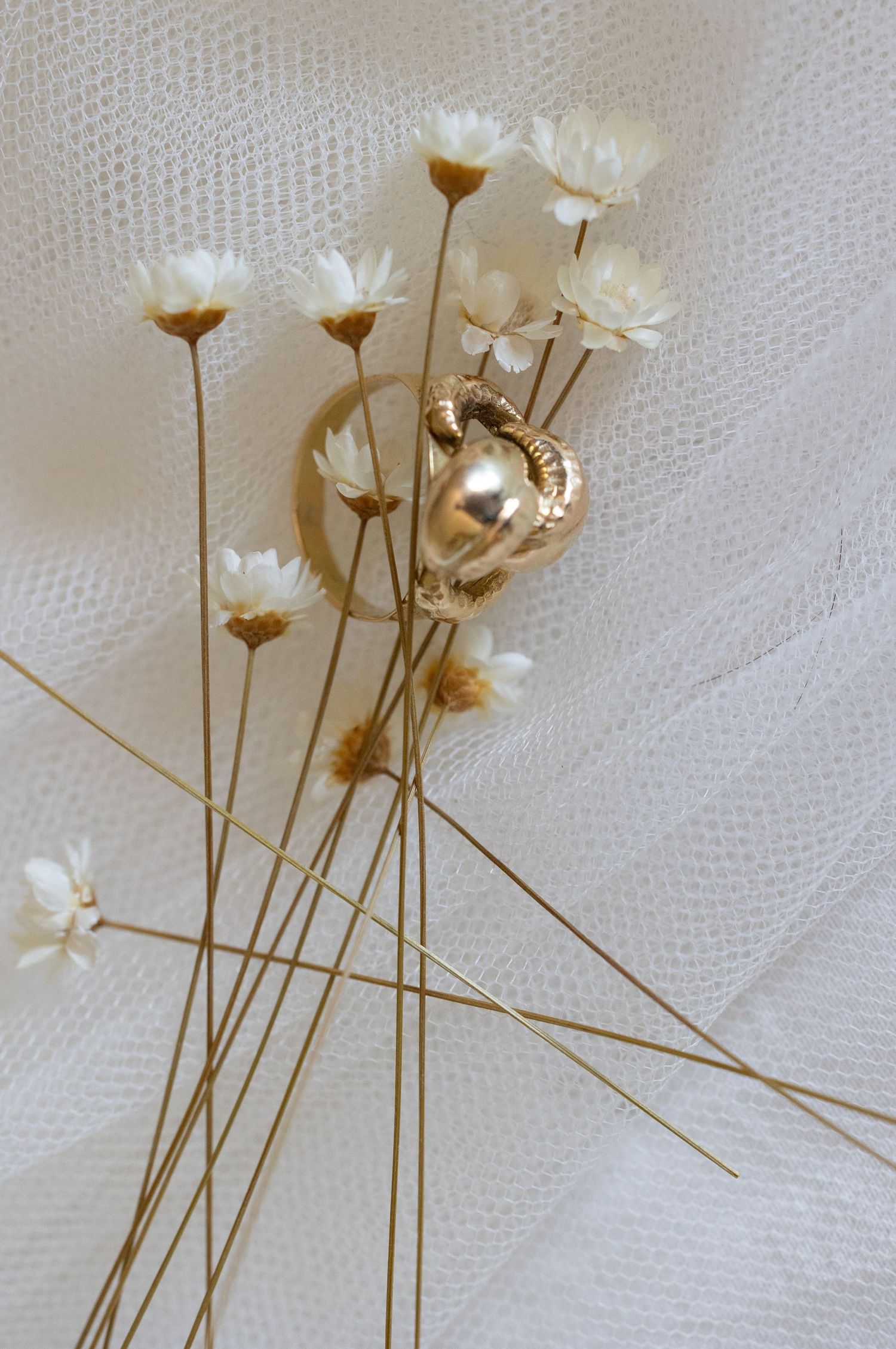Delicate white flower hairpins arranged on light fabric background.
