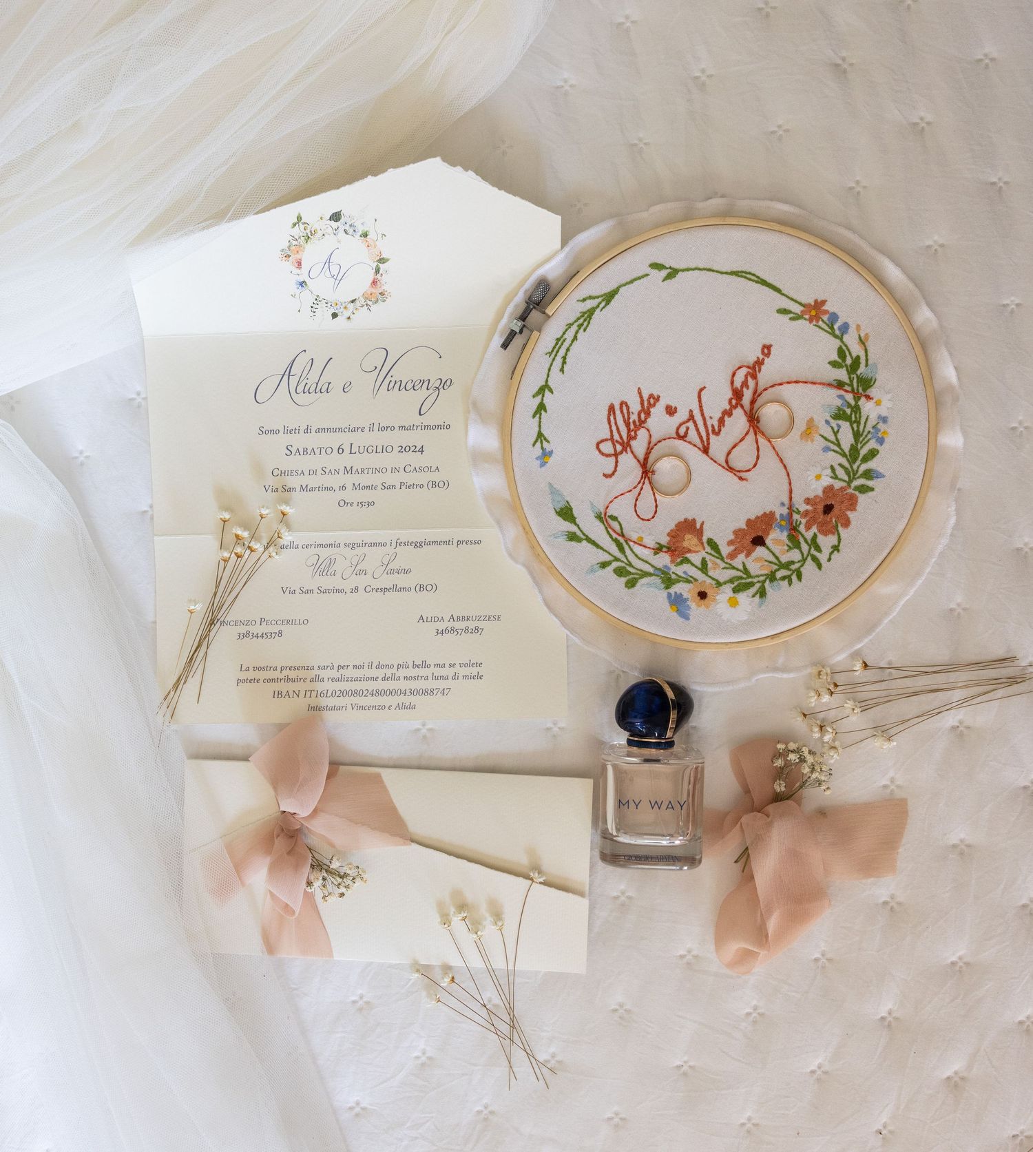 Delicate wedding invitations with floral embroidery hoops and pink ribbon details.