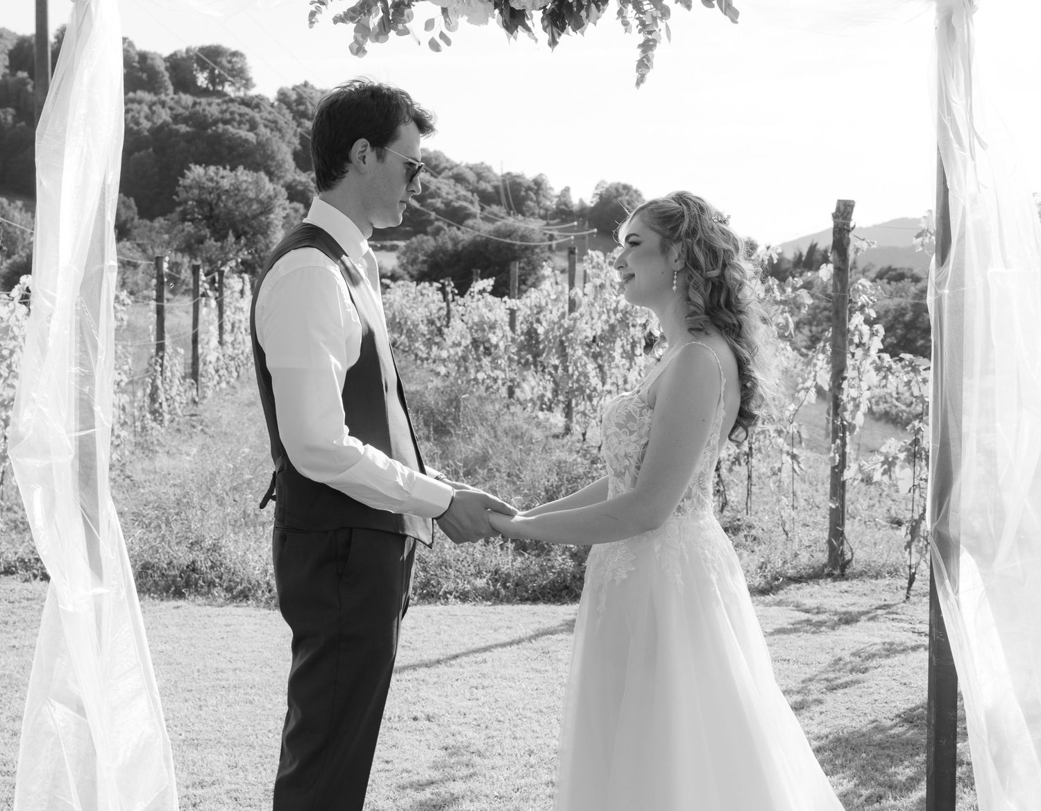 Black and white wedding ceremony photos in a rustic outdoor vineyard setting.