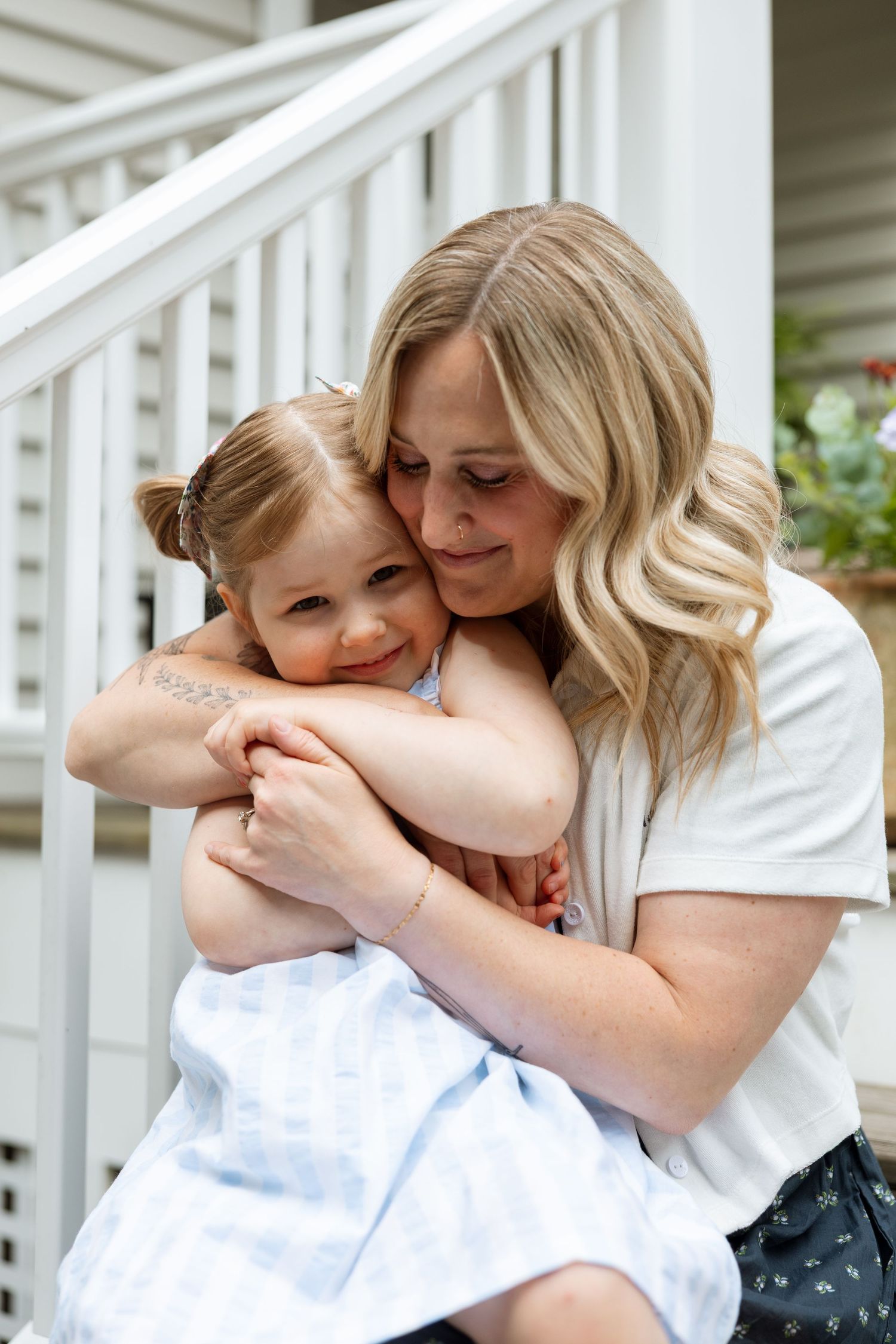 A collection of tender moments showing affectionate embraces in matching white outfits against a white porch backdrop.