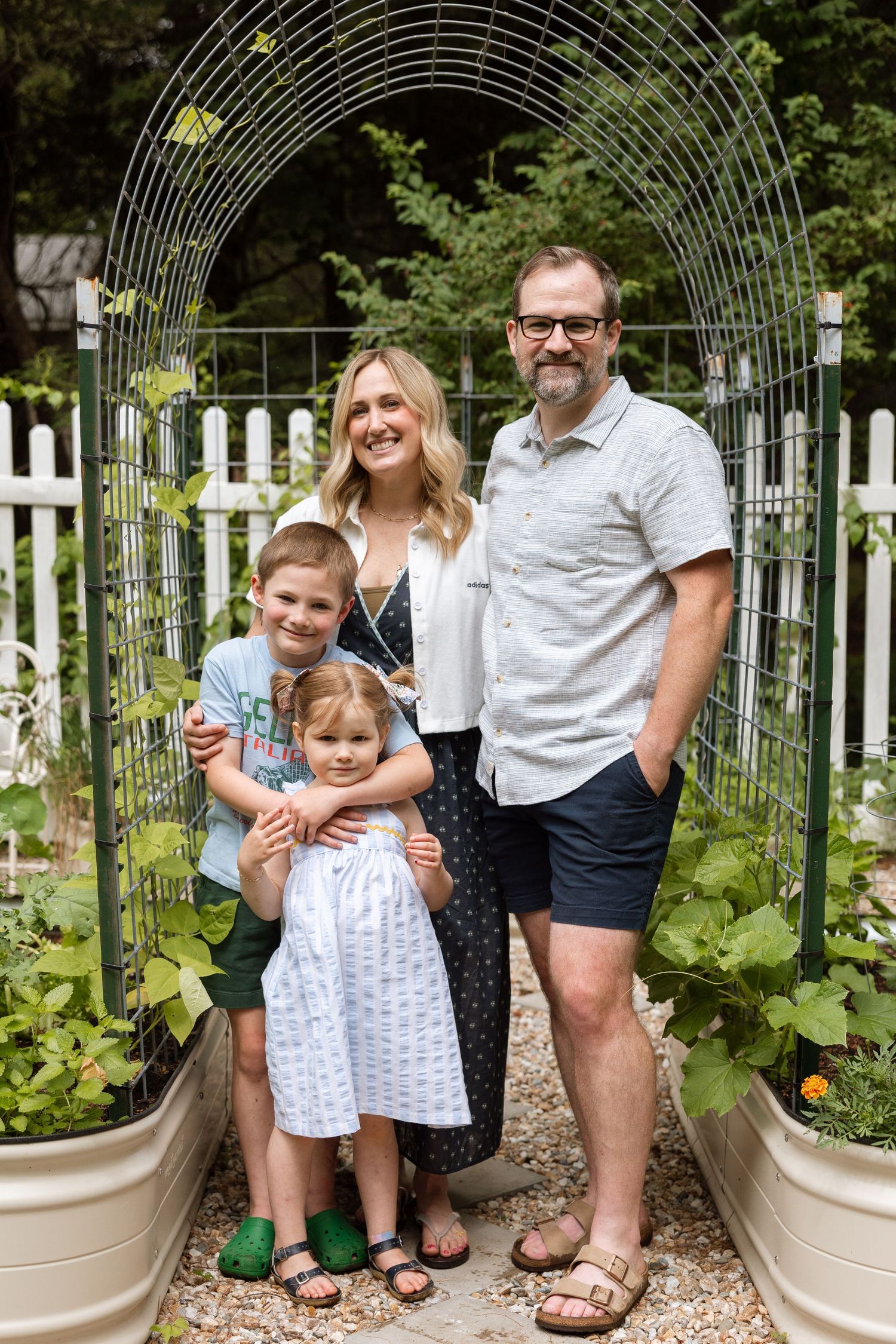 A series of progressive photos showing a family posing together in a garden arbor with climbing vines and potted plants.