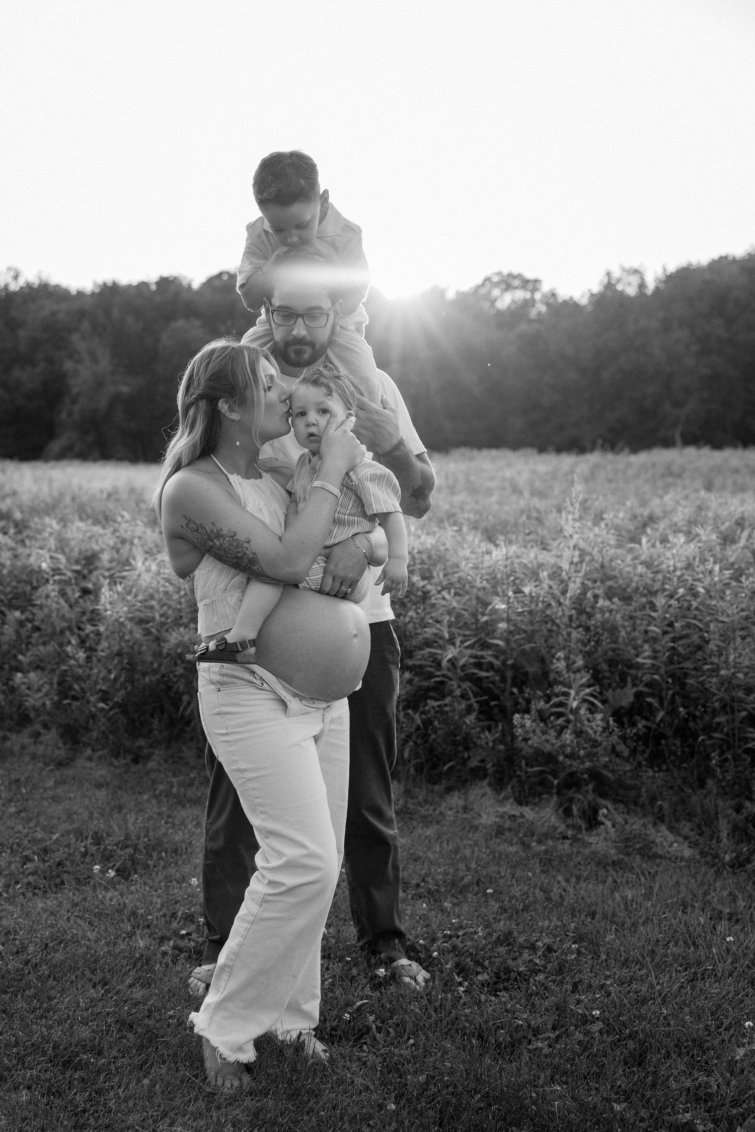 Romantic couple dancing together in a sunlit field, captured in a black and white photo sequence.