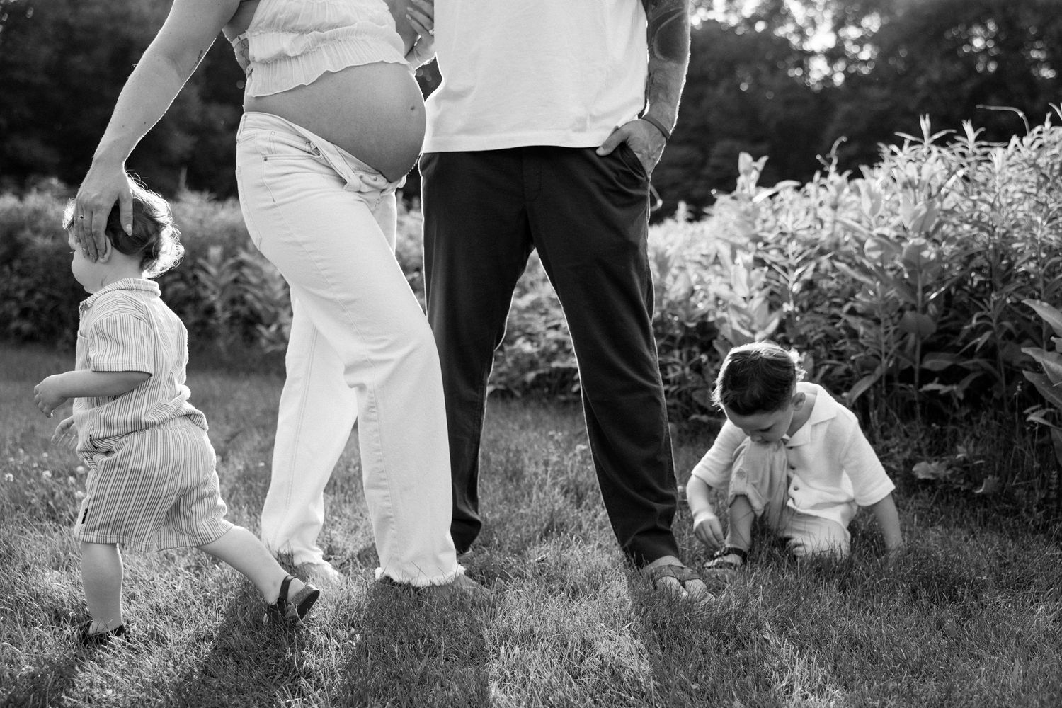 A joyful outdoor dance scene with people twirling and moving together through a garden in black and white.