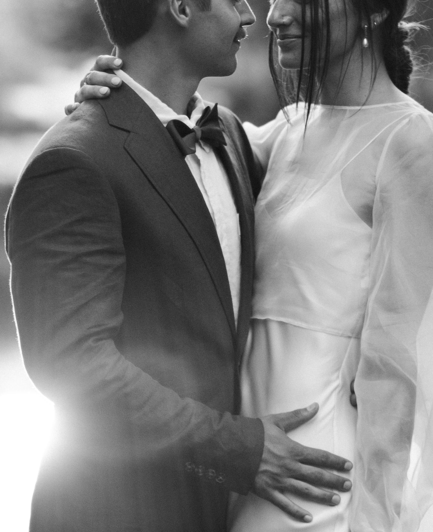 Intimate black and white portrait of couple in wedding attire.