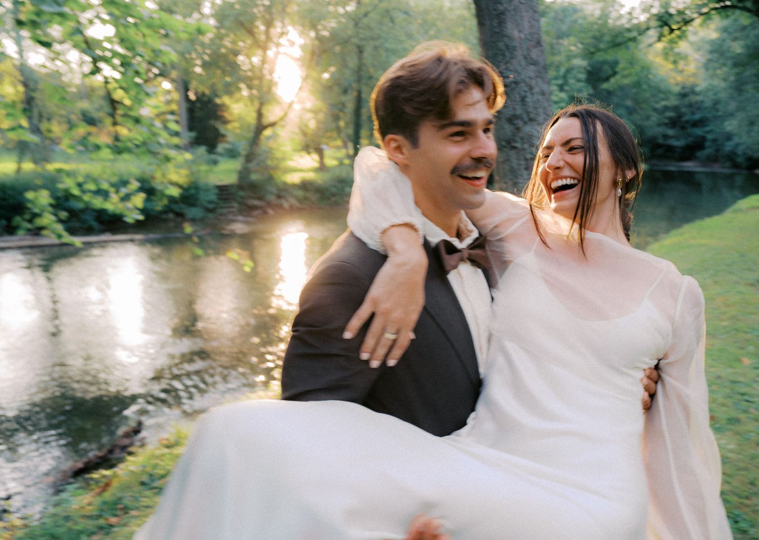 Couple shares romantic moments by a serene lake during sunset photo session.