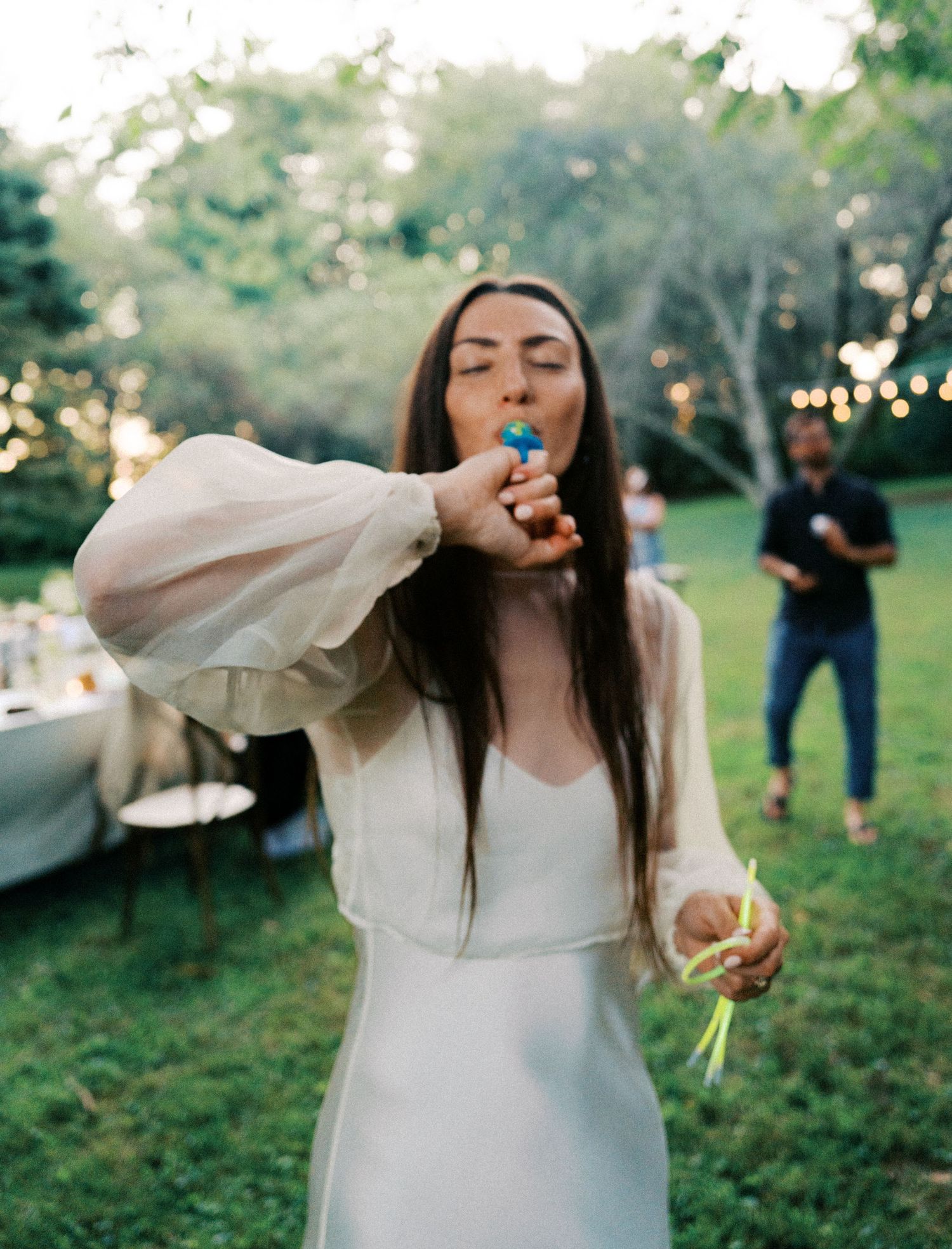Joyful celebration in a garden setting with flowing white dress and natural lighting.