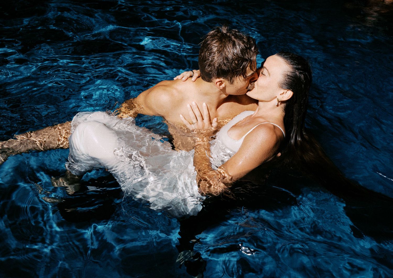 Artistic underwater photography series showing flowing white fabric in dark blue pool water.