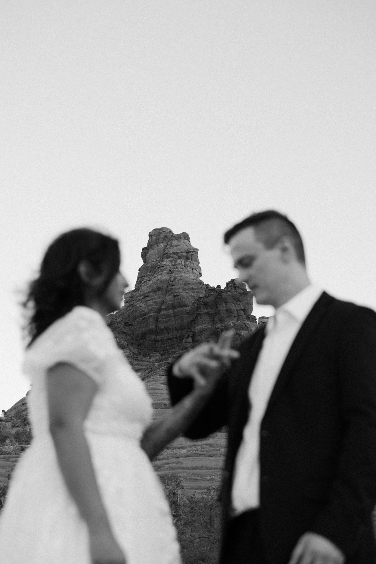 A black and white artistic wedding photo sequence shows a couple dancing and embracing with rock formations in background.