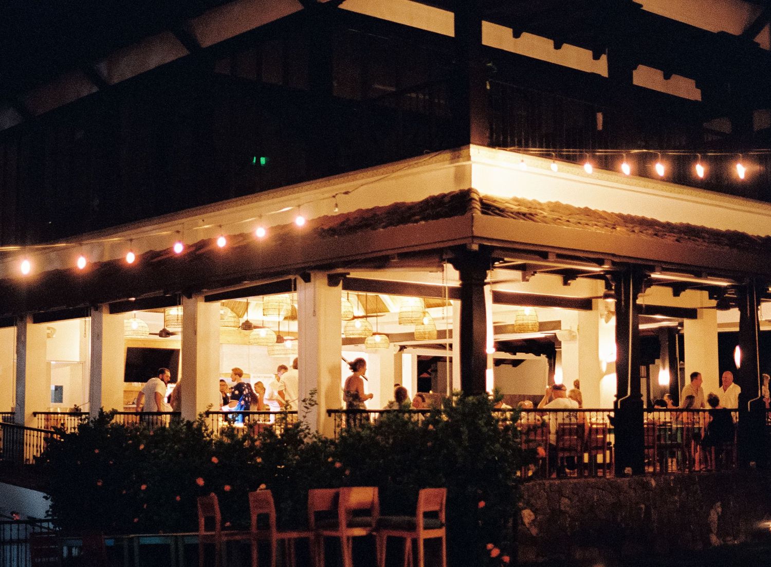 Outdoor restaurant patio lit with warm string lights at dusk creating an ambient atmosphere.
