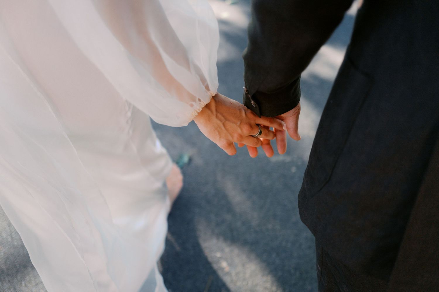 Elegant wedding ceremony details with hands exchanging rings in soft focus.
