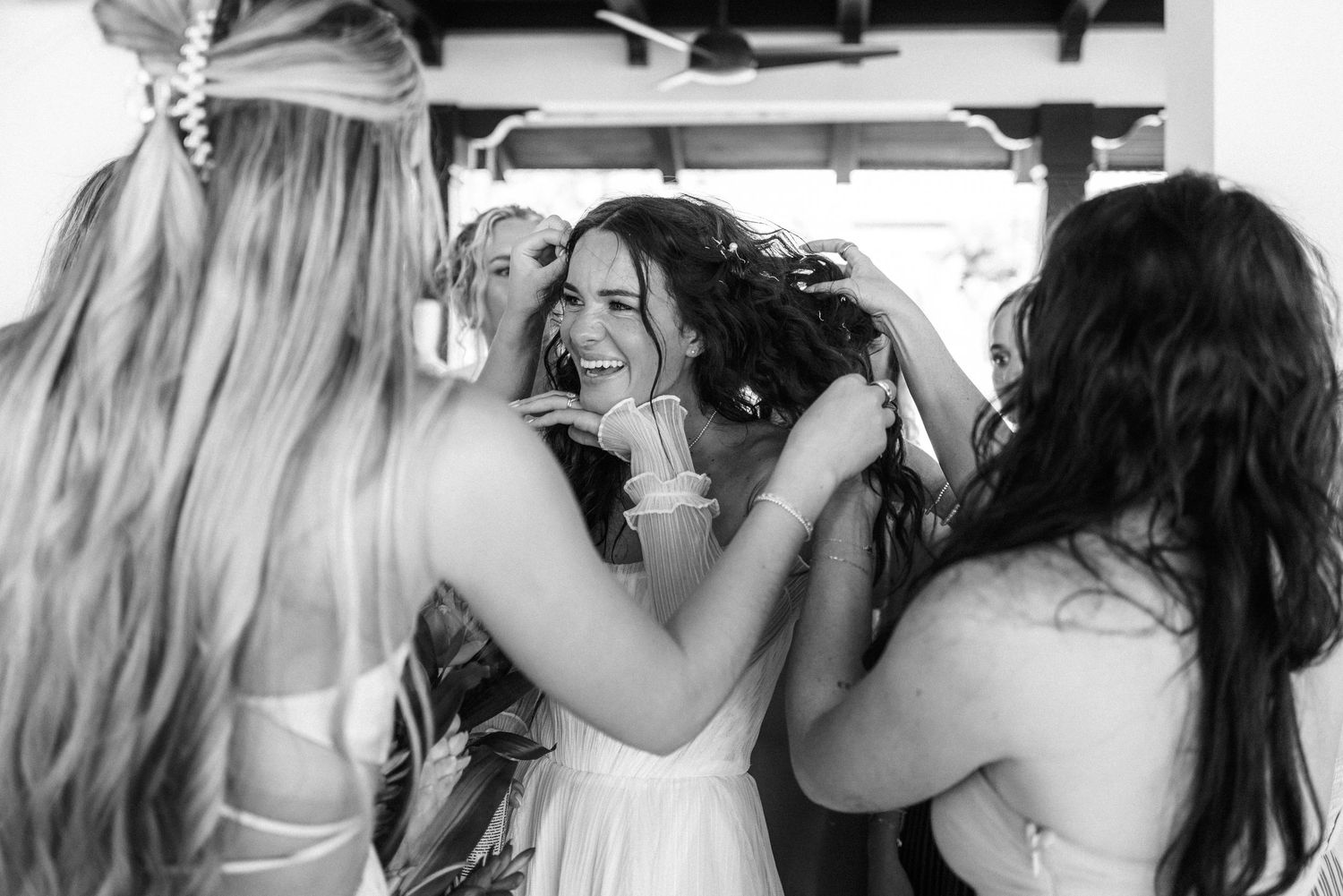 A group of bridesmaids in matching dresses pose together in black and white photography.
