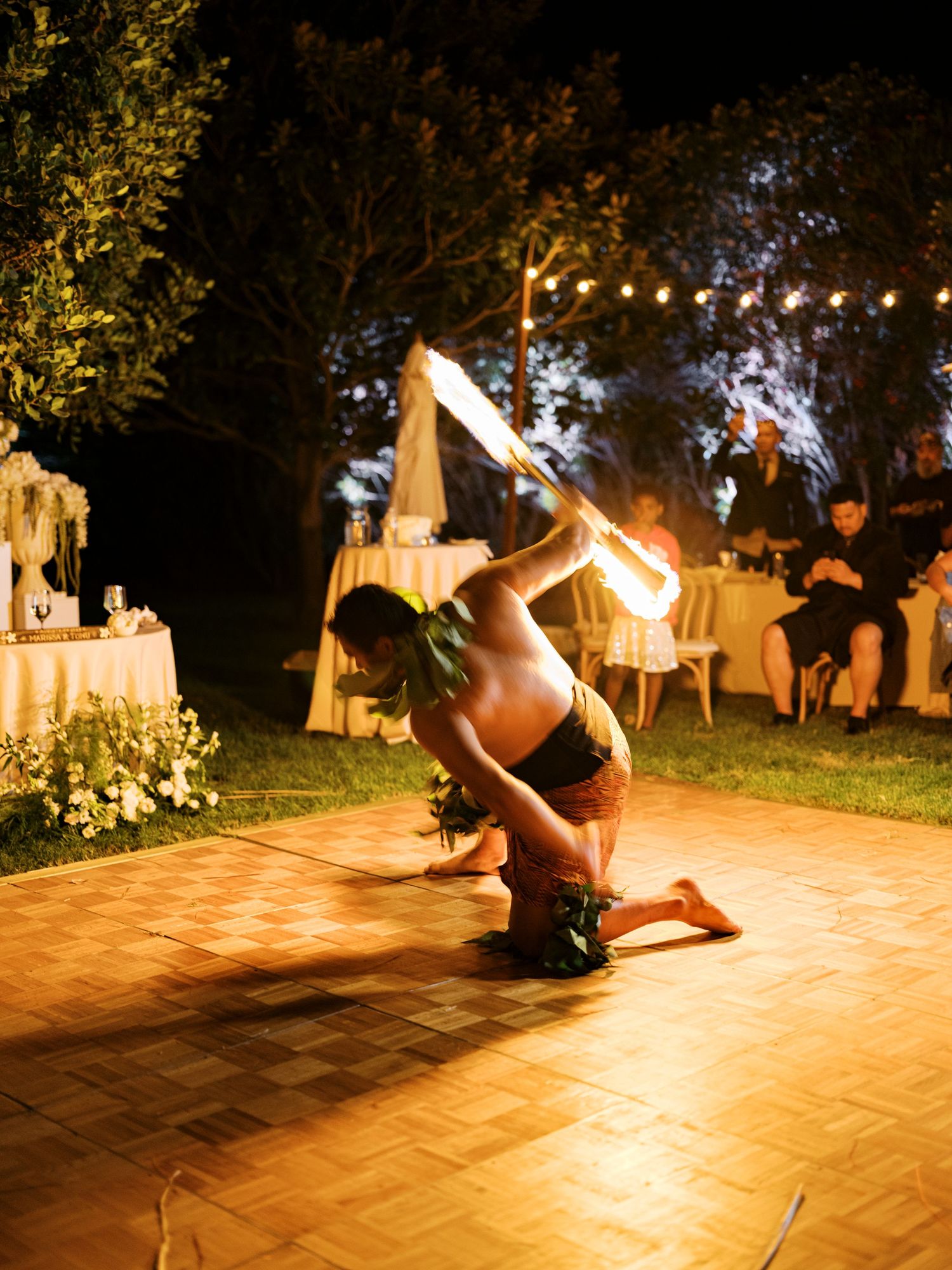 A dance performance sequence on an outdoor patio lit by string lights at night showing graceful spinning movements.