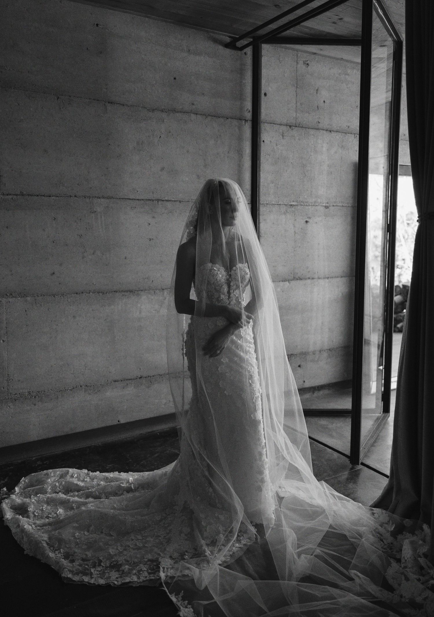 A series of five black and white photographs showing a figure in a flowing bridal veil against a rustic wooden wall.
