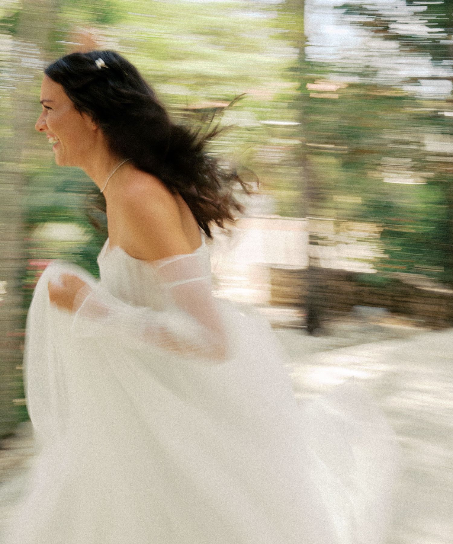 Motion-blurred sequence of a white dress flowing in the wind against a natural outdoor backdrop.