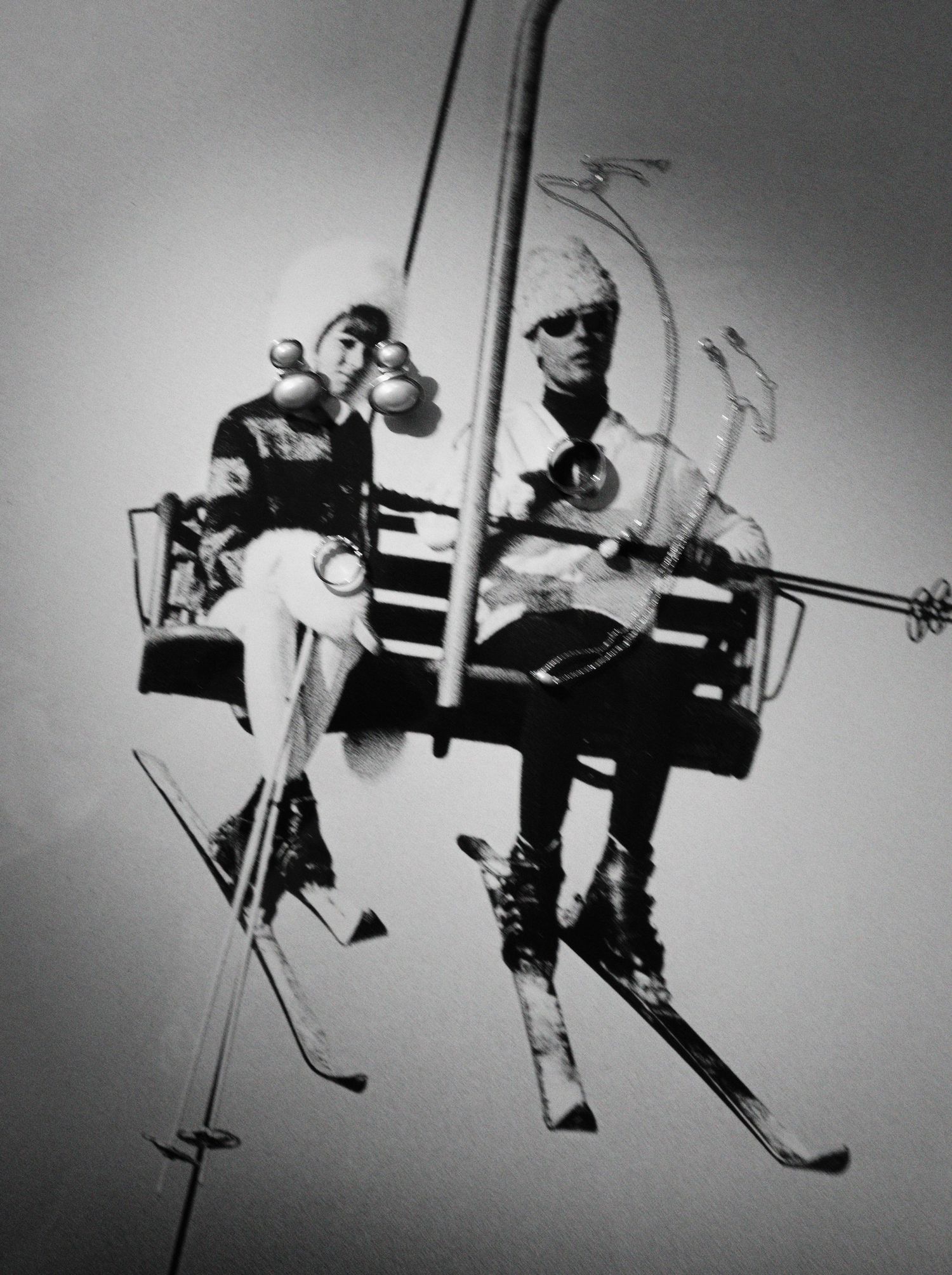 Black and white silhouettes of people riding on a ski lift against a bright background.