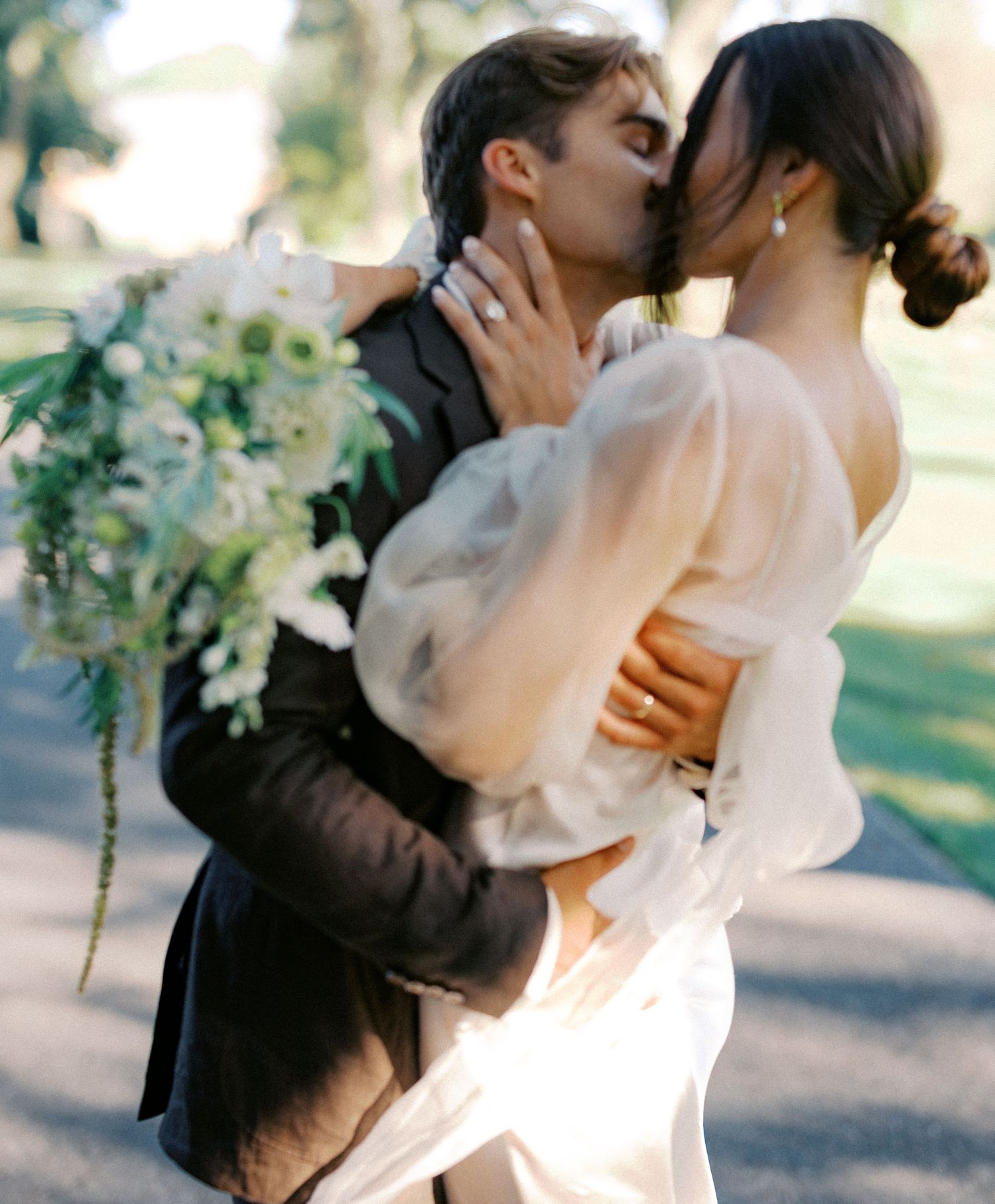 Romantic wedding moment captured in an elegant outdoor garden setting with floral decorations.