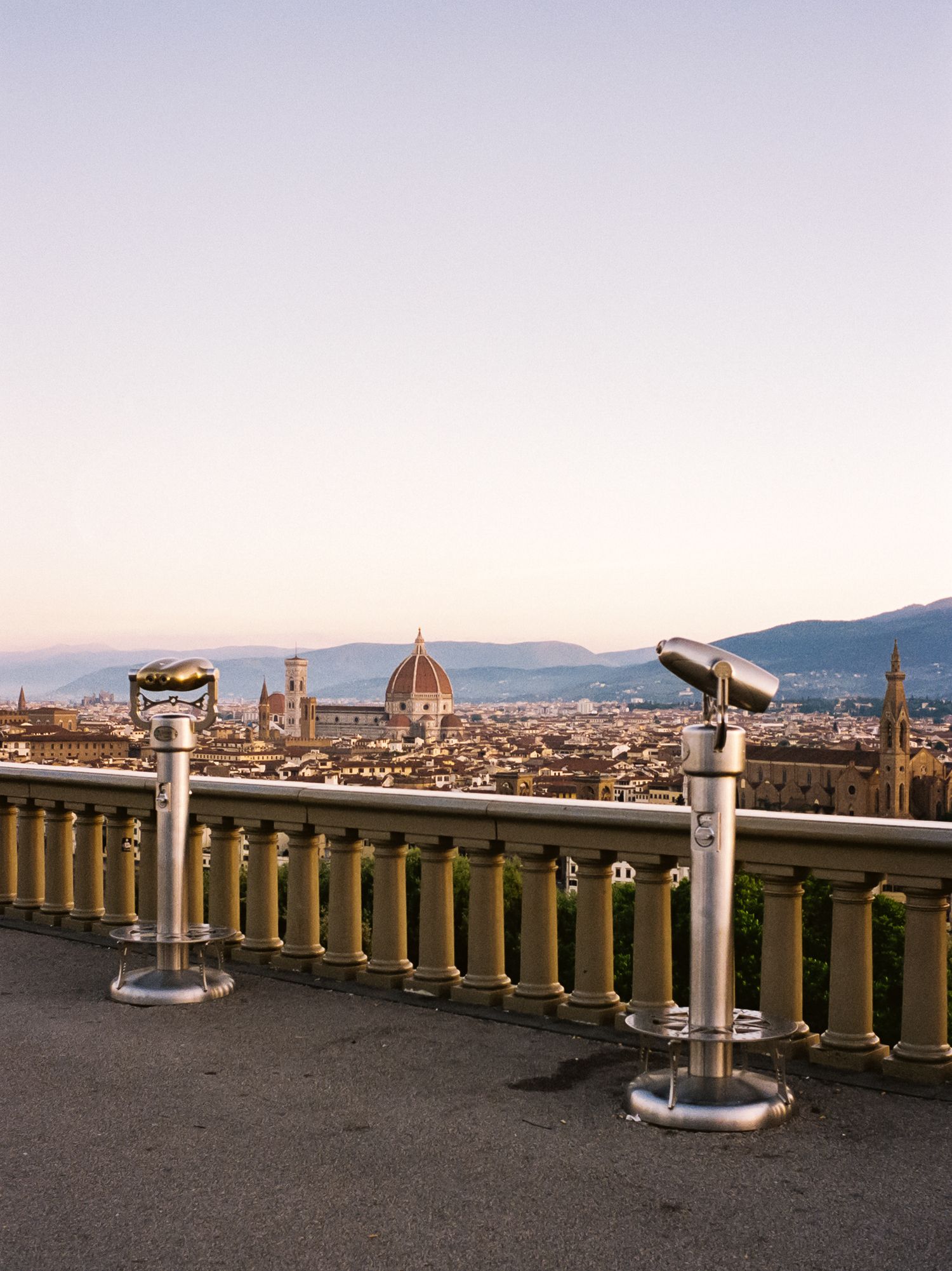 Panoramic view of Florence cityscape with iconic Duomo cathedral and historic buildings at sunset.
