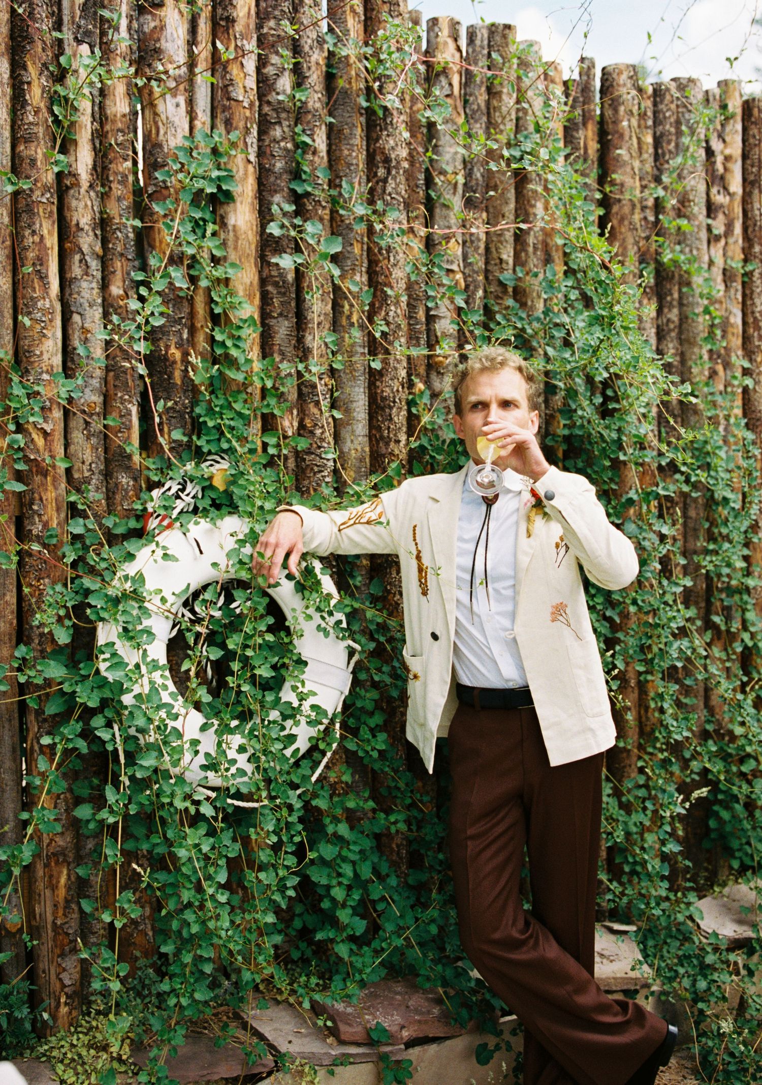 Rustic wooden fence backdrop decorated with climbing vines and greenery.