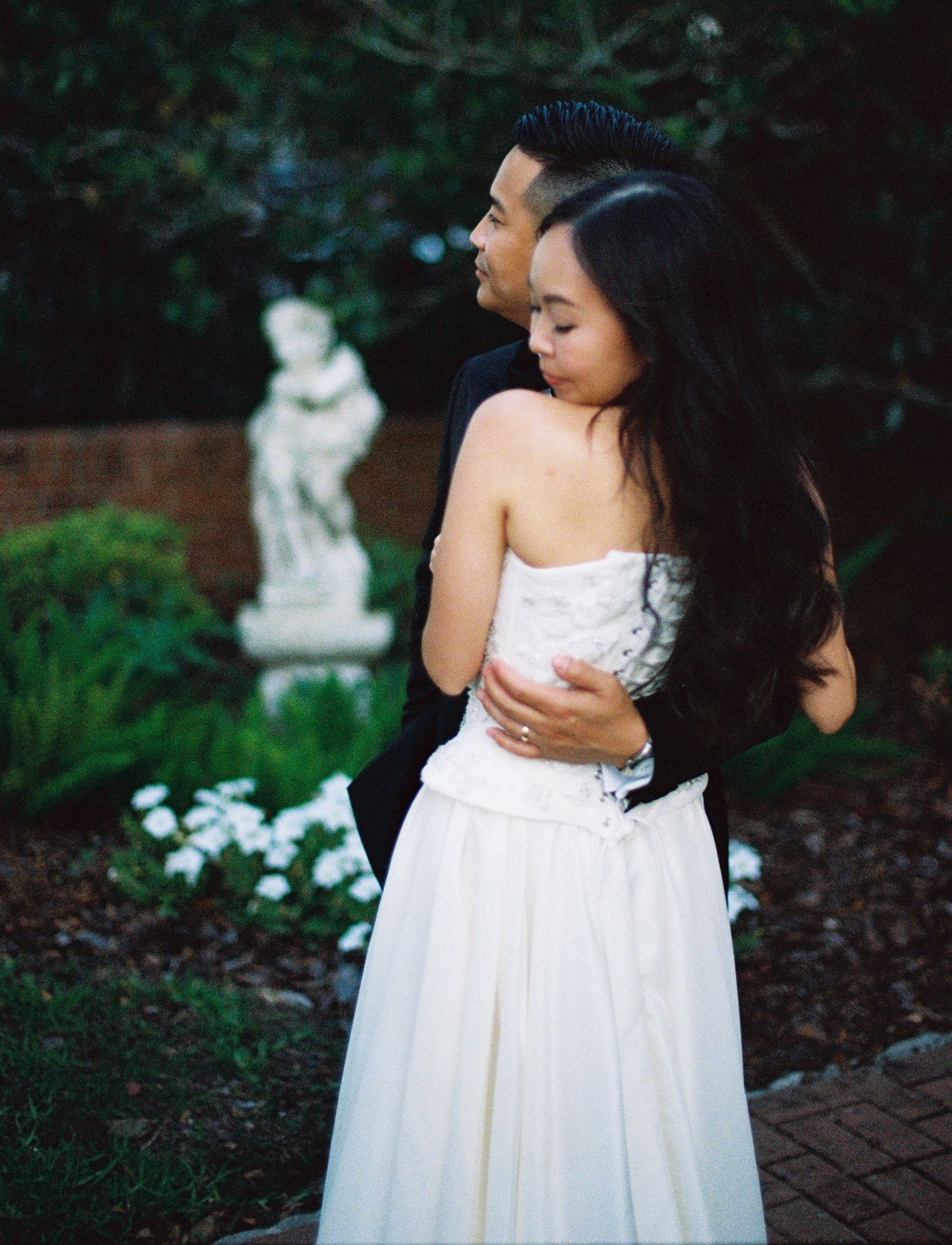 A series of photos showing a white flower girl dress against a garden backdrop with statues and greenery.