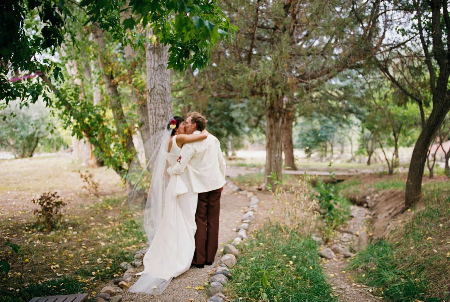 Elegant wedding photography in a wooded outdoor setting with natural greenery.