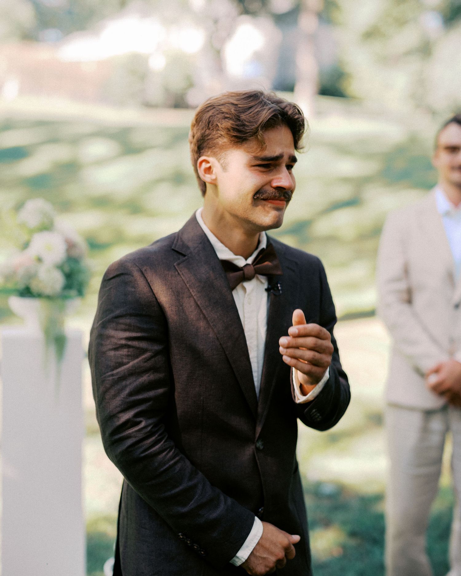 Emotional candid moment captured during an outdoor wedding ceremony.