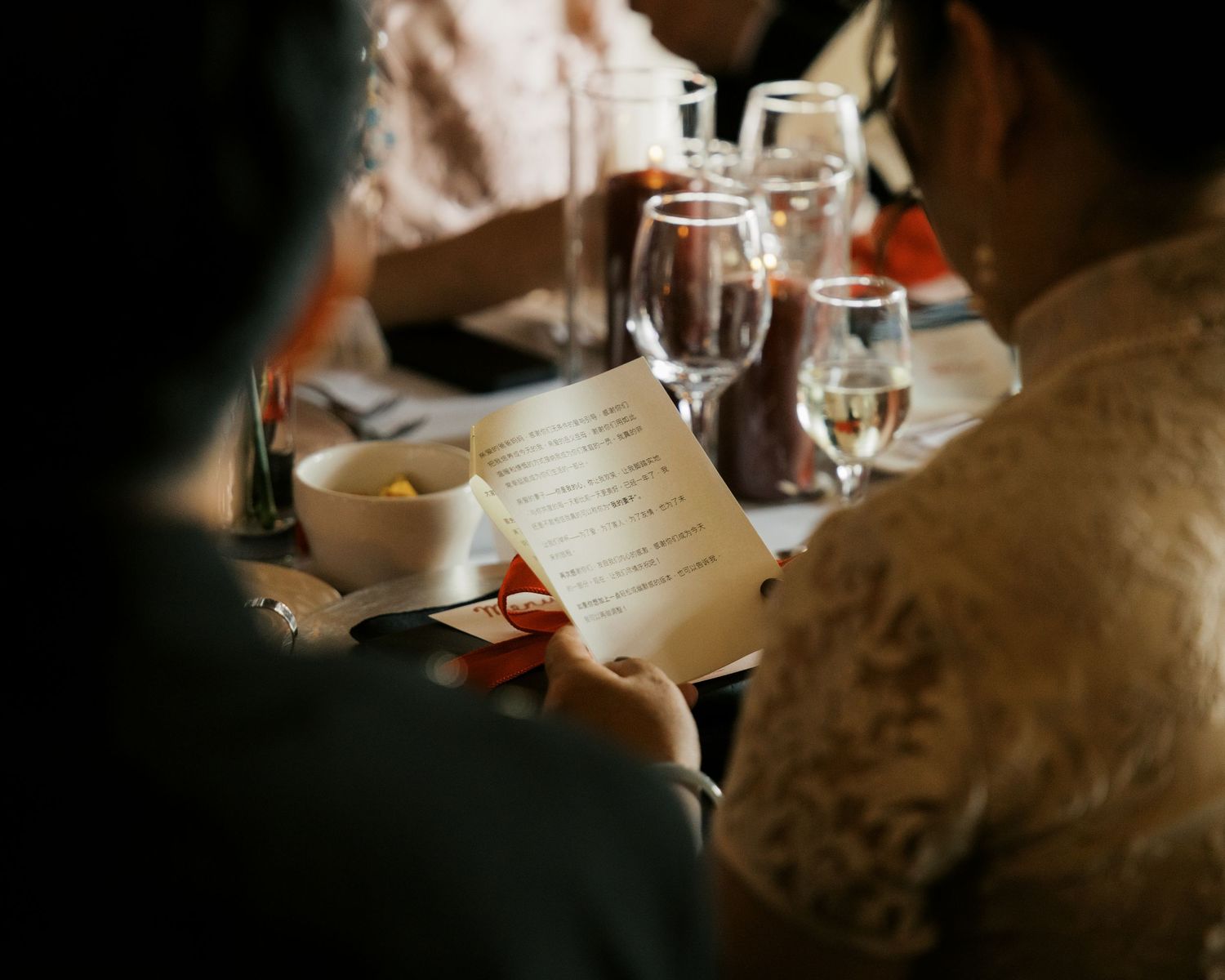 Close-up details of wedding reception table settings in dim lighting.