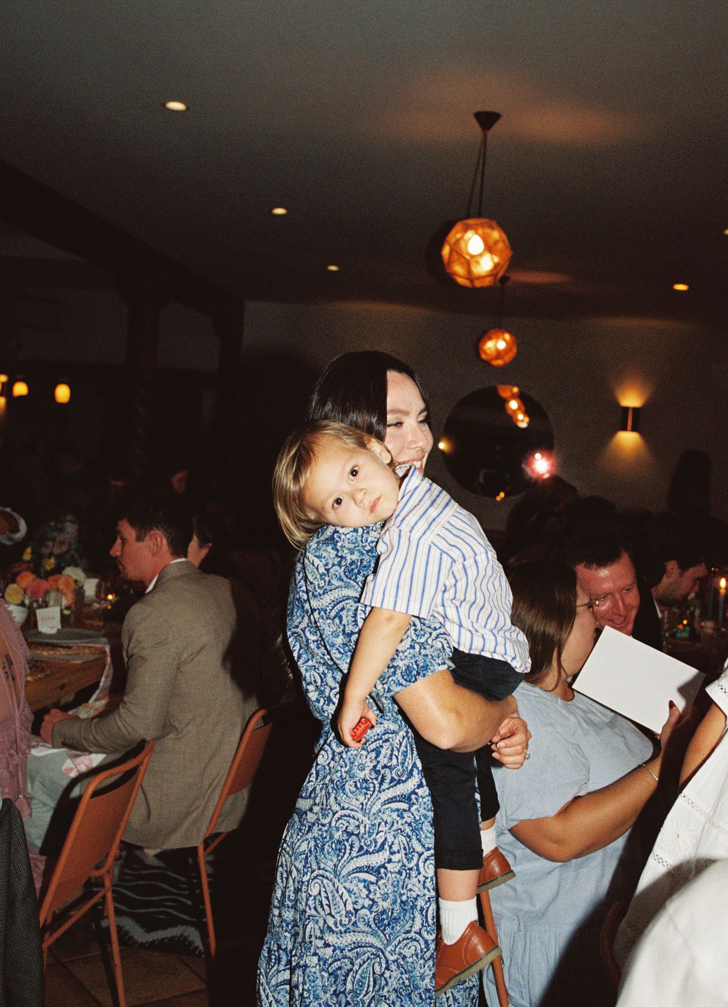 Couples dancing together at a dimly lit event venue with pendant lighting creating a romantic atmosphere.