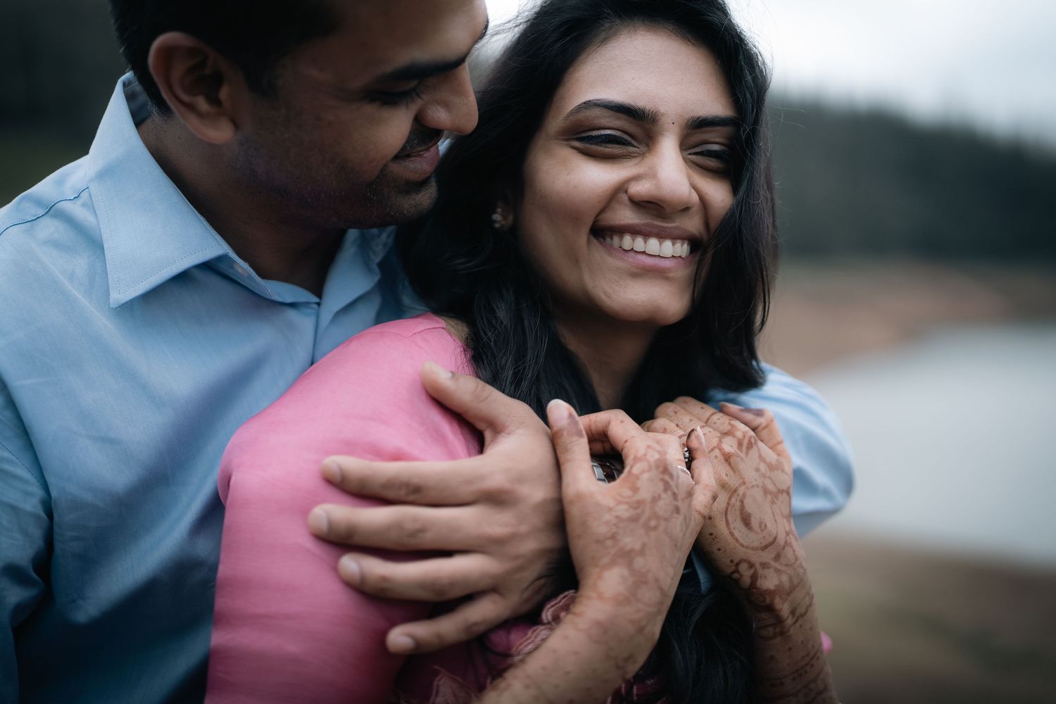 Loving couple sharing tender moment outdoors with pink dress accent.