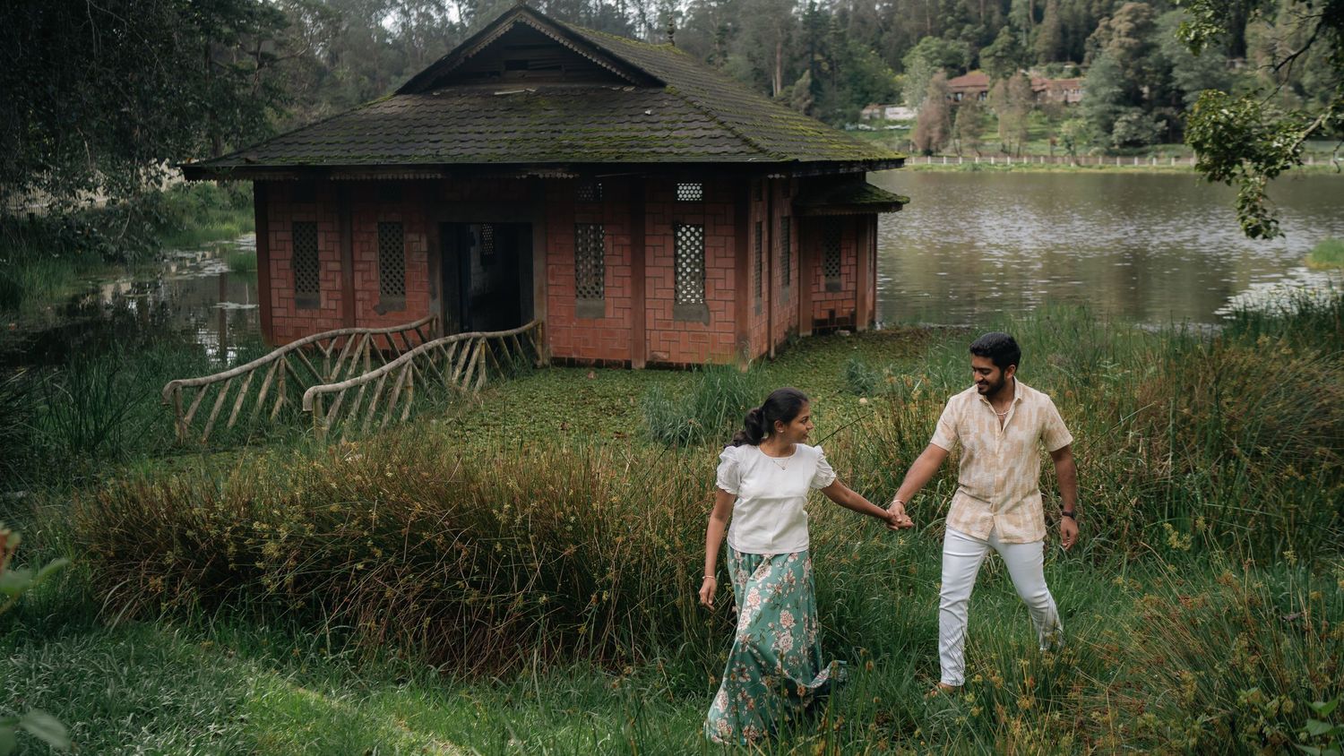 People interact near rustic wooden cabins surrounded by lush greenery.