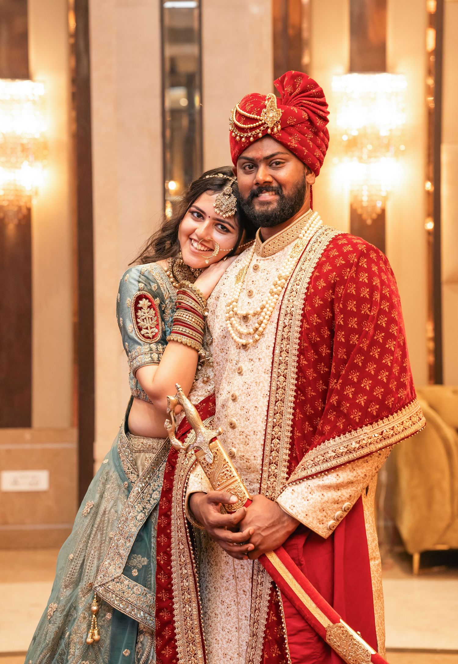Wedding celebration in traditional Indian attire with ornate decorations and warm lighting.