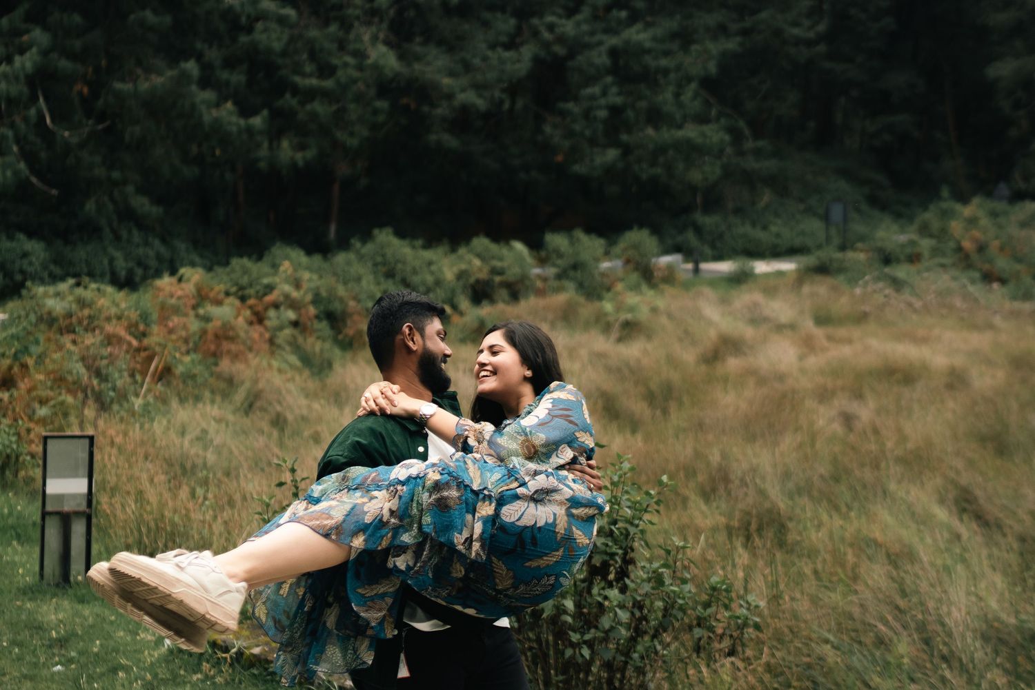 People share intimate moments in a grassy field during golden hour.