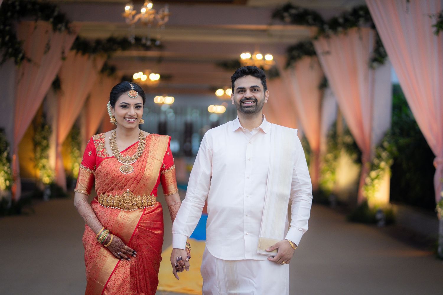 Traditional Indian wedding ceremony setup with elegant pink drapes and chandeliers.