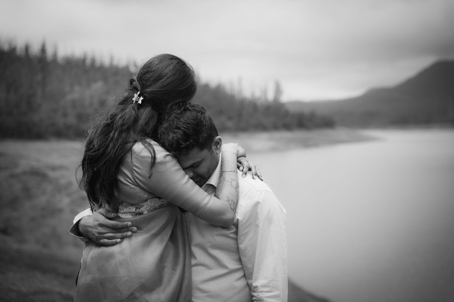 Romantic black and white photo captured against a serene lake backdrop.