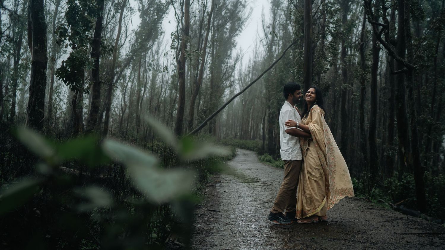A misty forest path with a couple embracing in ethereal lighting.
