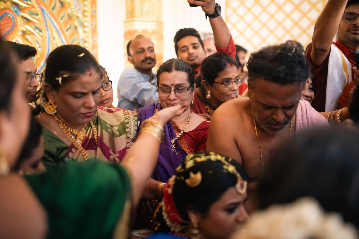 Crowd of celebrants in colorful traditional Indian clothing gather joyfully during a cultural ceremony or celebration.