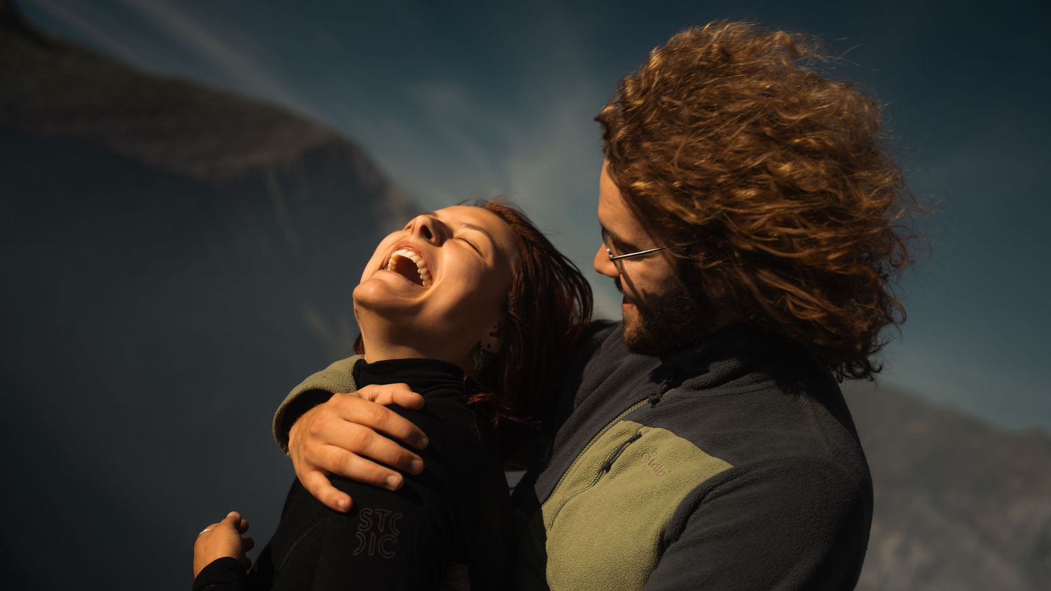 A dramatic series of six connected images showing a couple embracing and dancing against a dark moody sky.