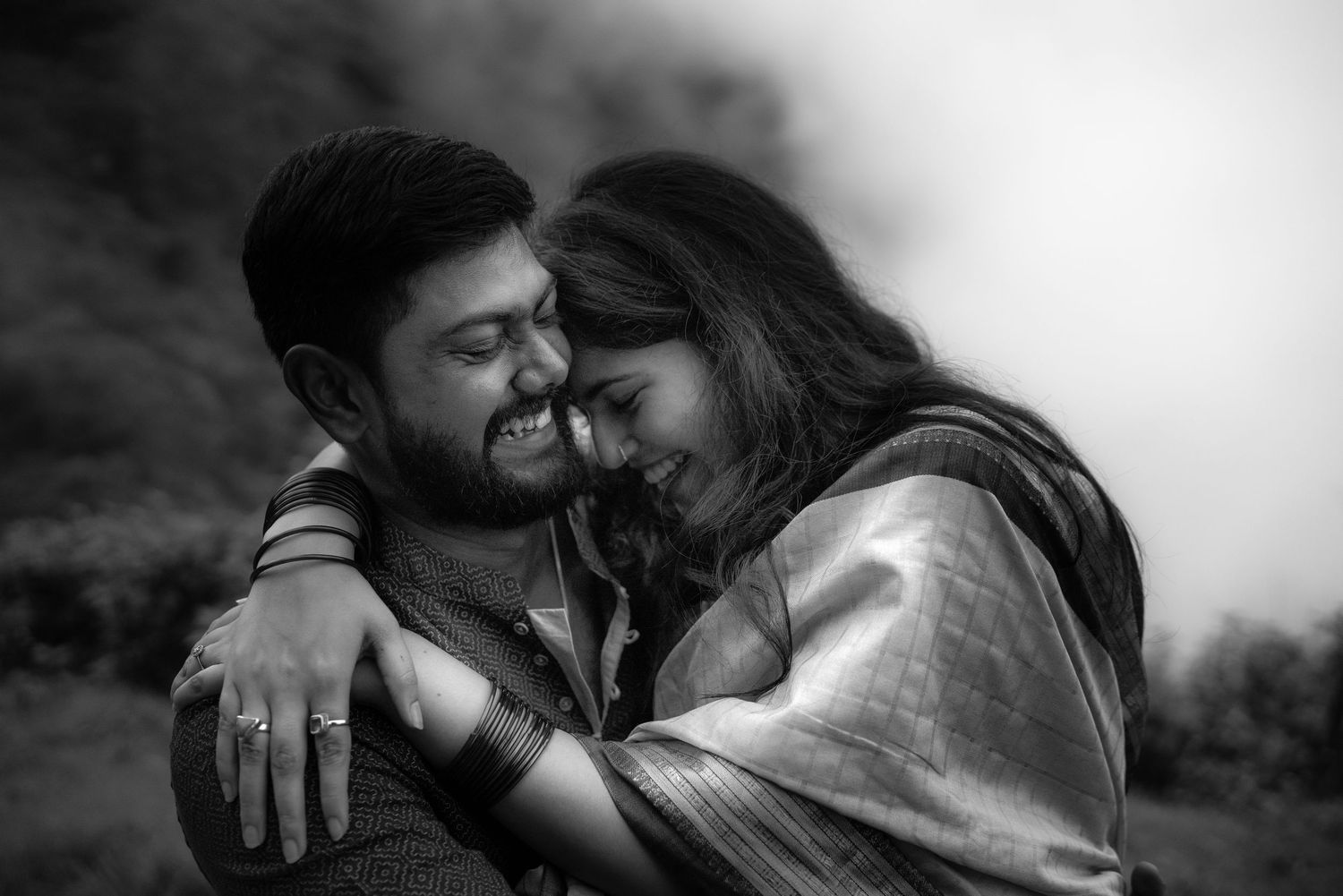 Intimate black and white portrait of a couple sharing a tender moment.